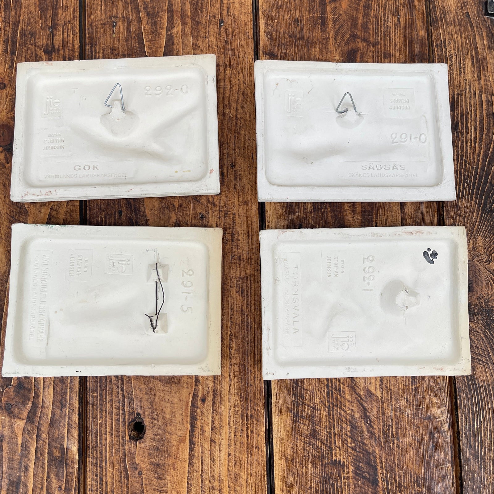 Four white plastic packets on a wooden surface