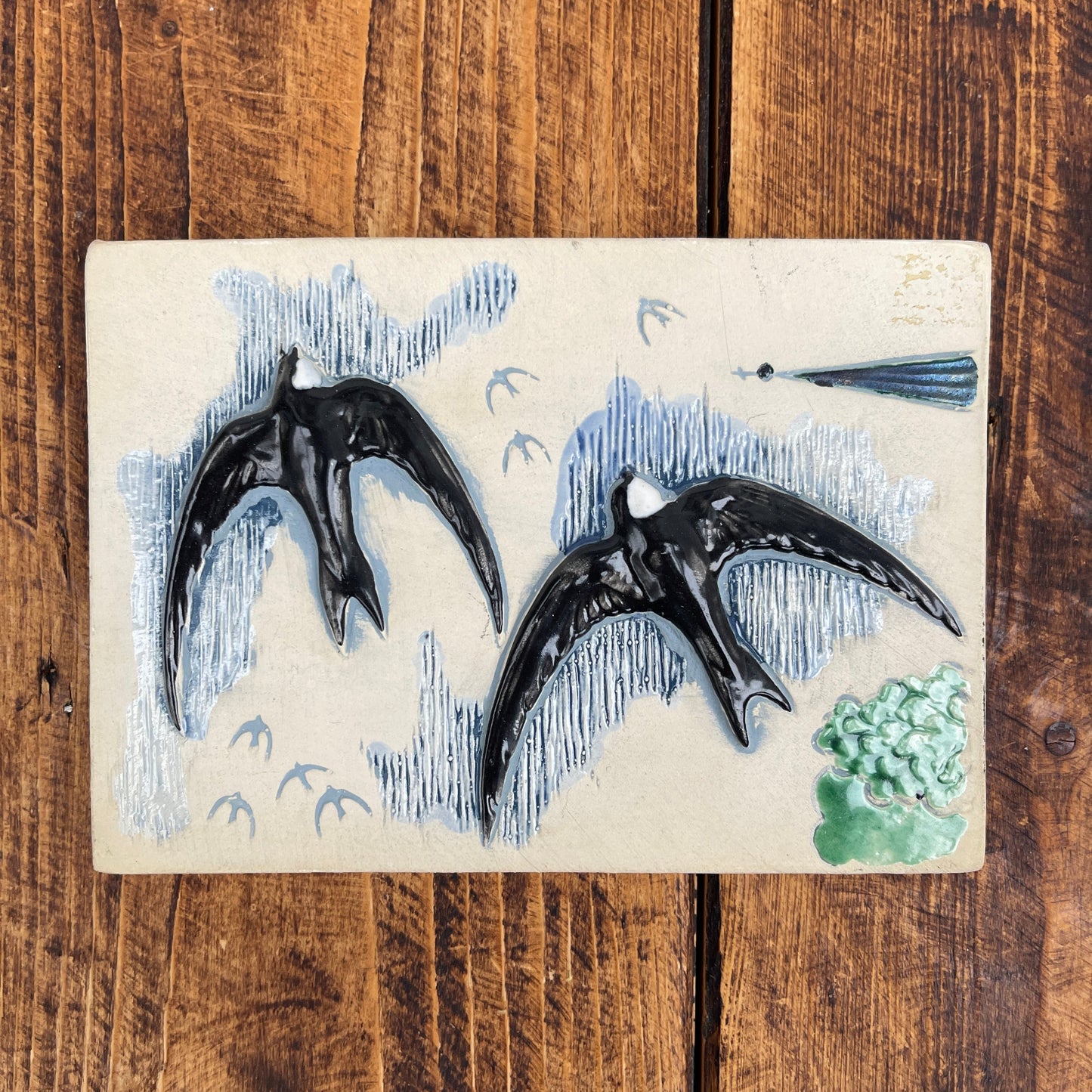 Decorative ceramic birds on a wooden surface