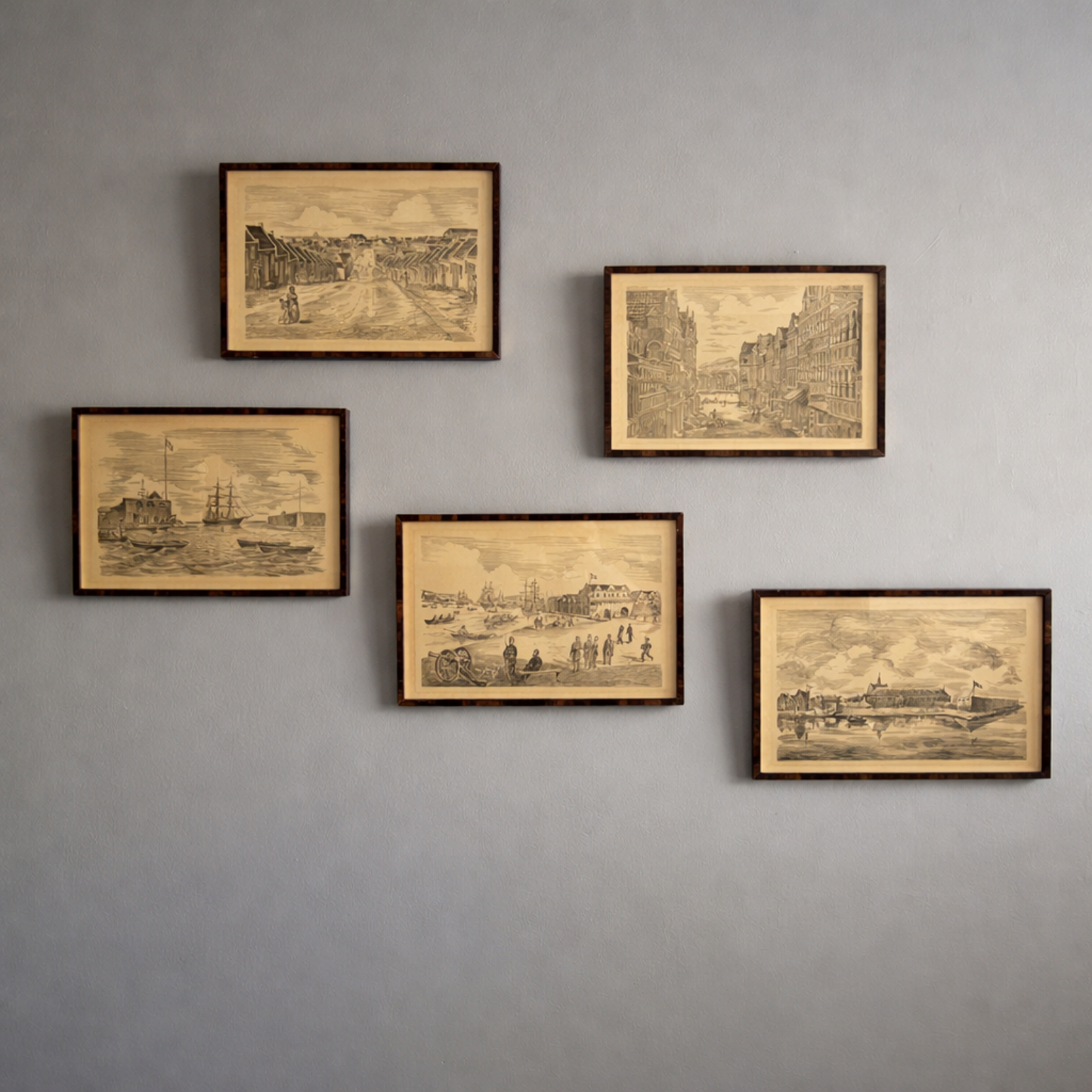 Five framed vintage-style cityscape prints on a gray wall.
