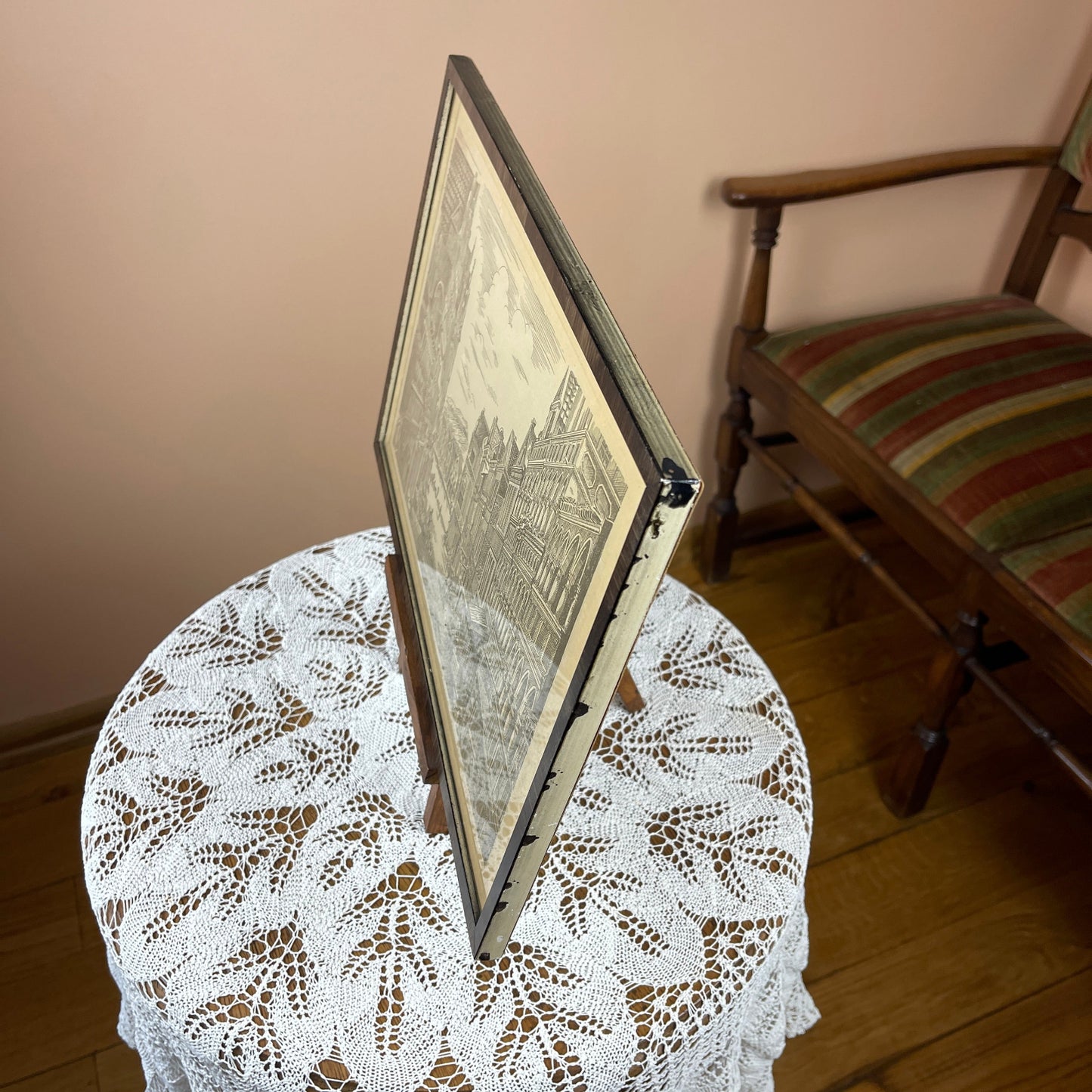 Framed picture on a lace tablecloth with a chair in the background
