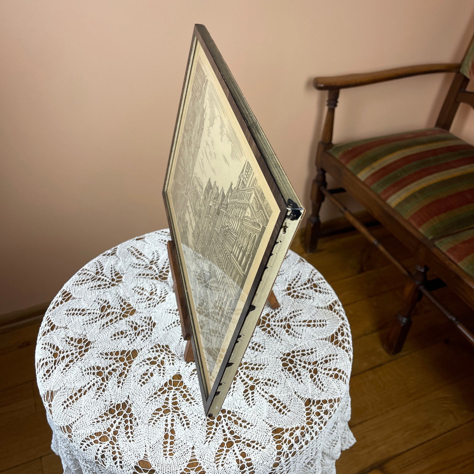 Framed picture on a lace tablecloth with a chair in the background