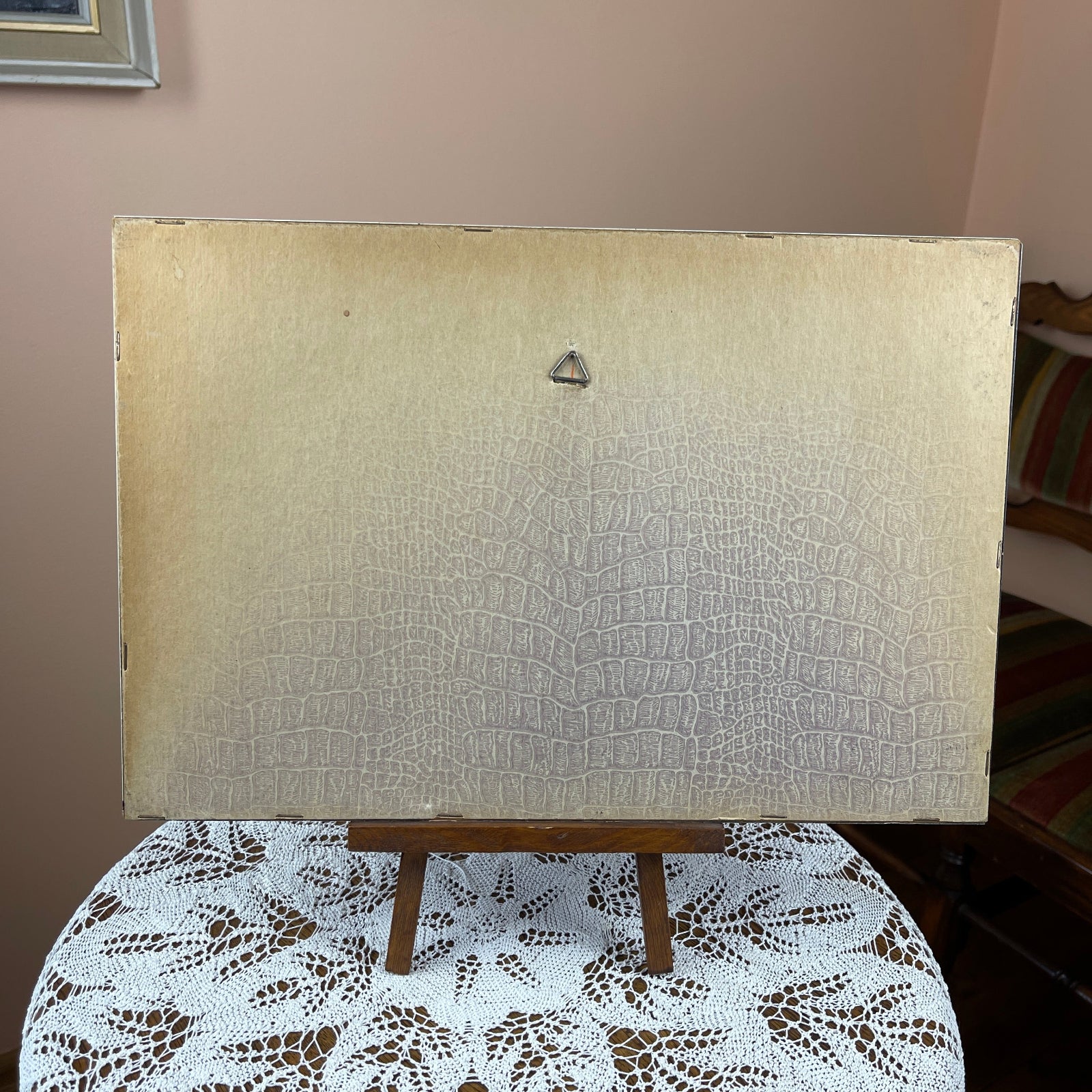 Textured beige panel on a stand with a patterned tablecloth underneath