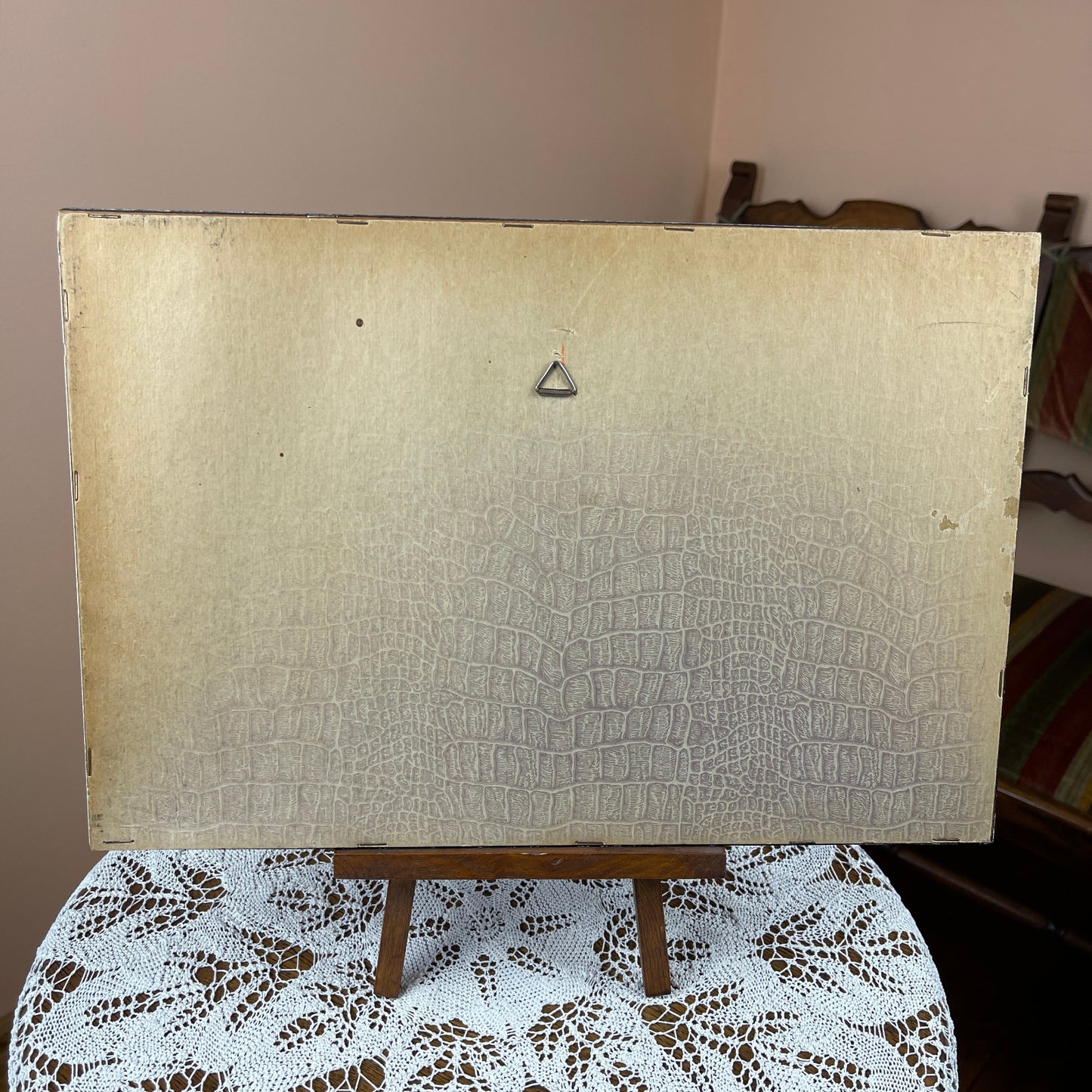 Beige textured board on a wooden easel with a brown background