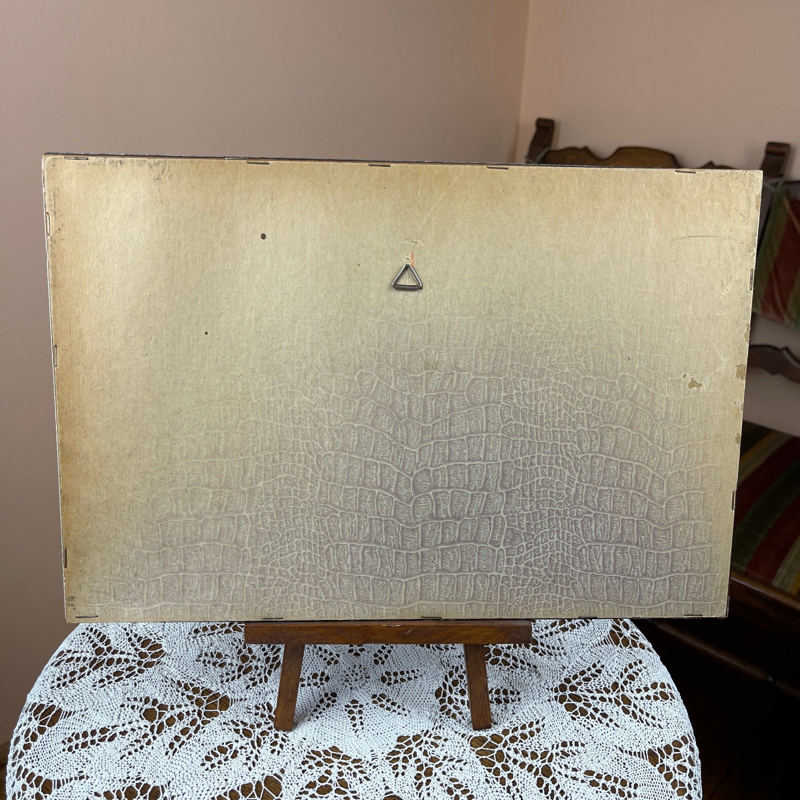 Beige textured board on a wooden easel with a brown background