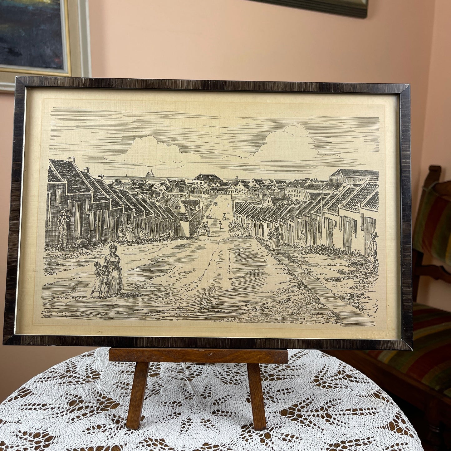 Framed black and white print of a street scene on a lace tablecloth