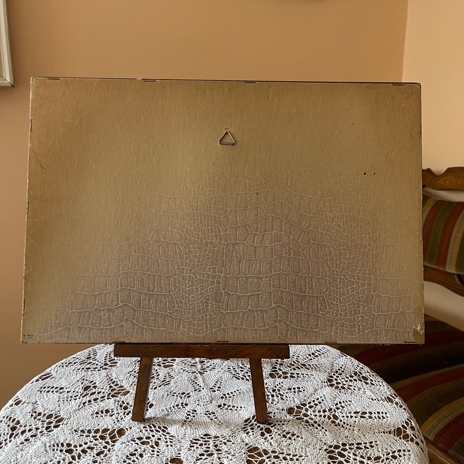 Beige textured board on a stand with a lace tablecloth underneath