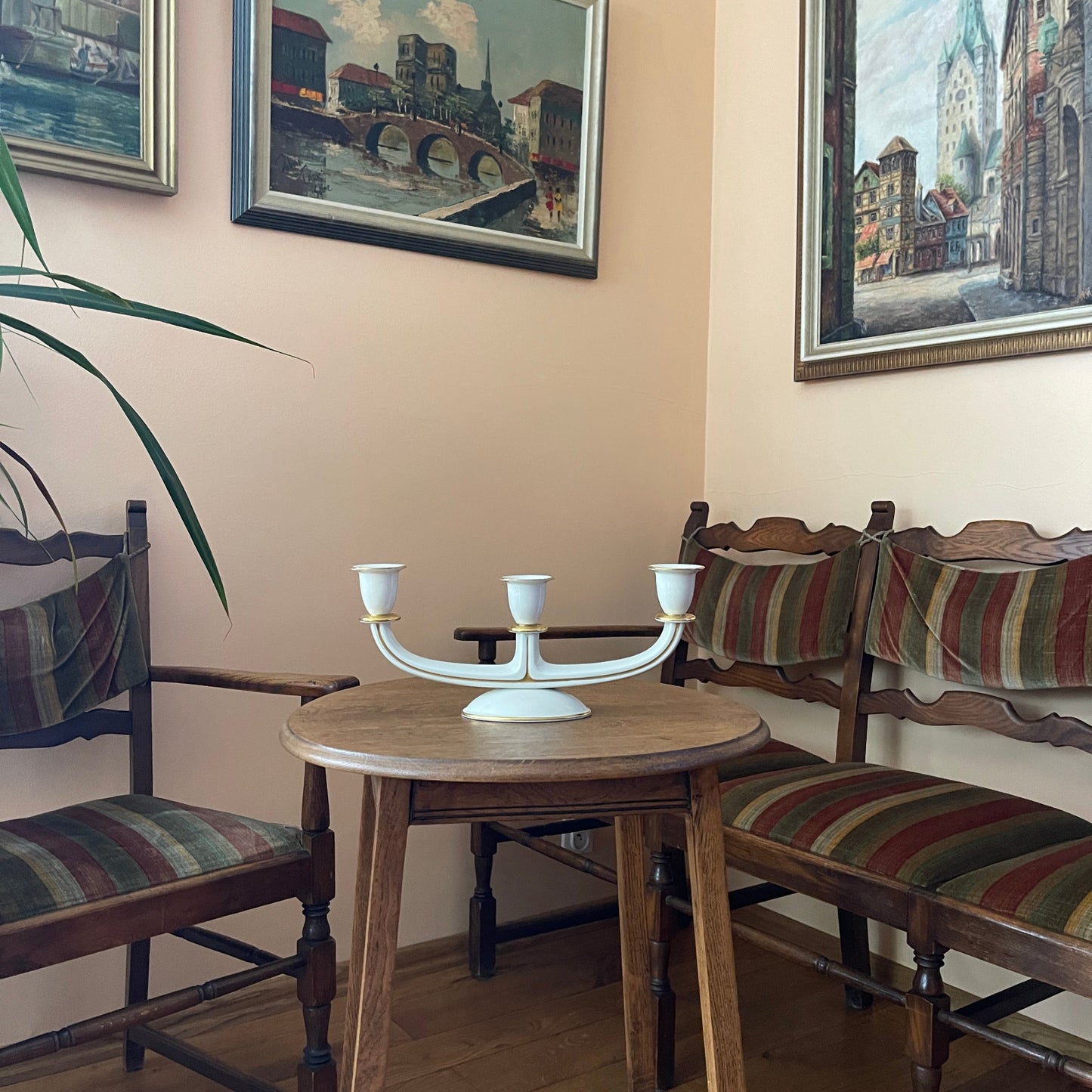 Dining area with wooden table and chairs, decorated with framed artworks on the wall.