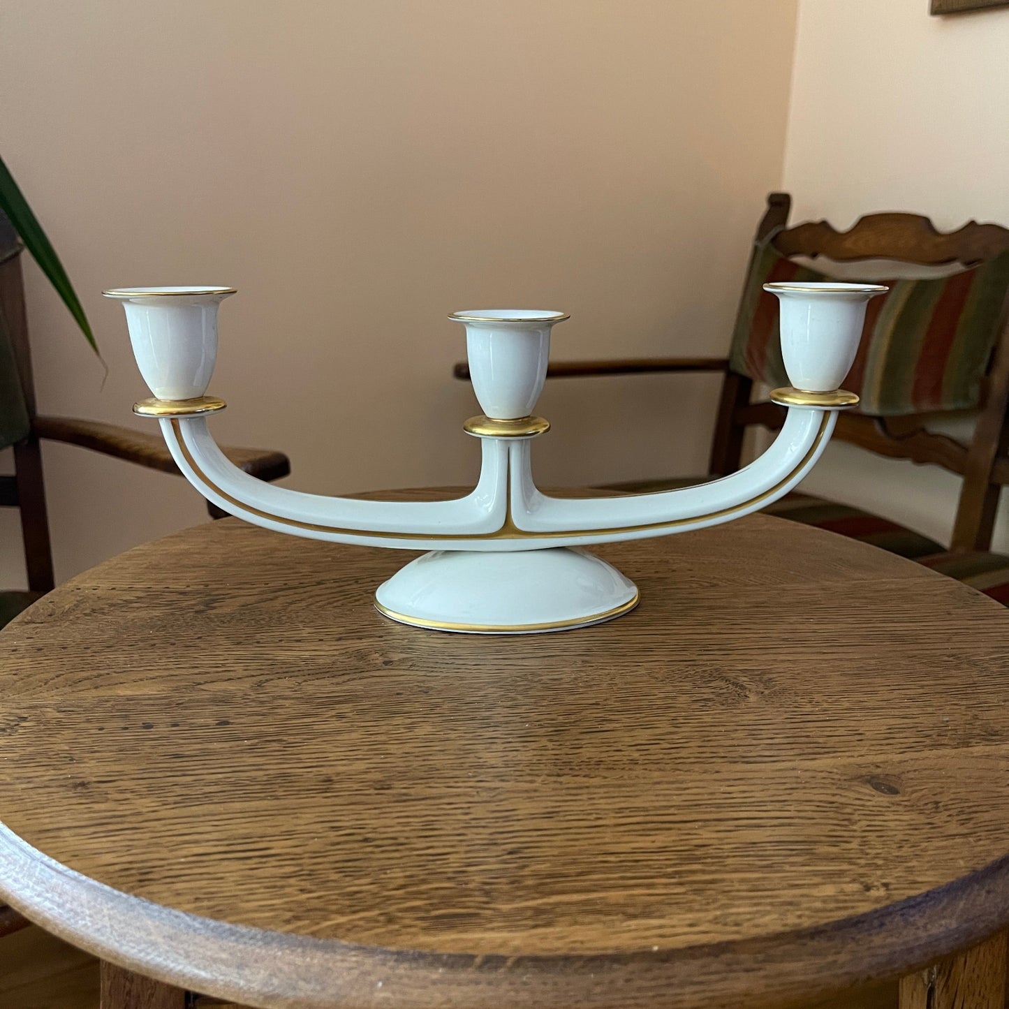 White candelabrum with gold accents on a wooden table