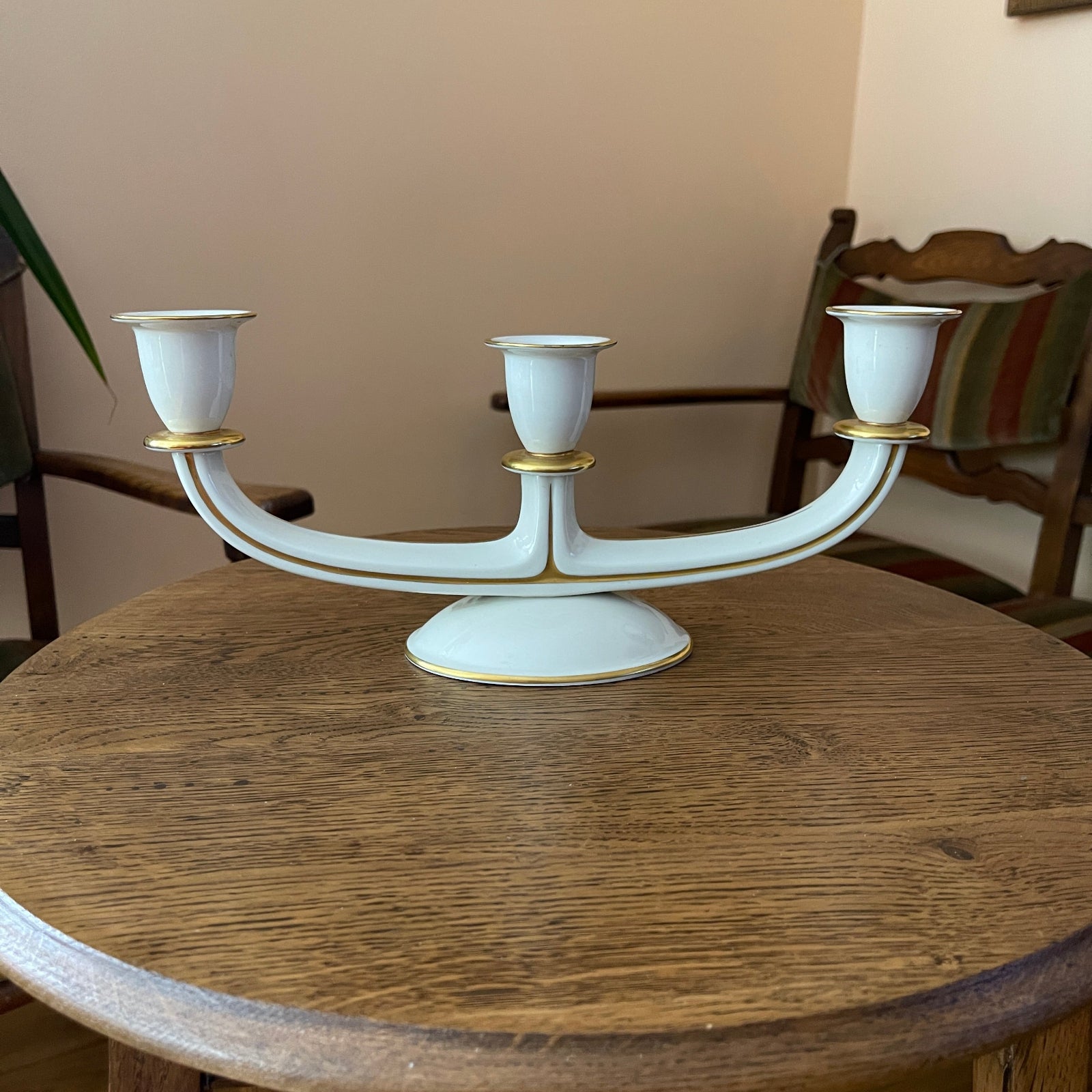 White candelabrum with gold accents on a wooden table