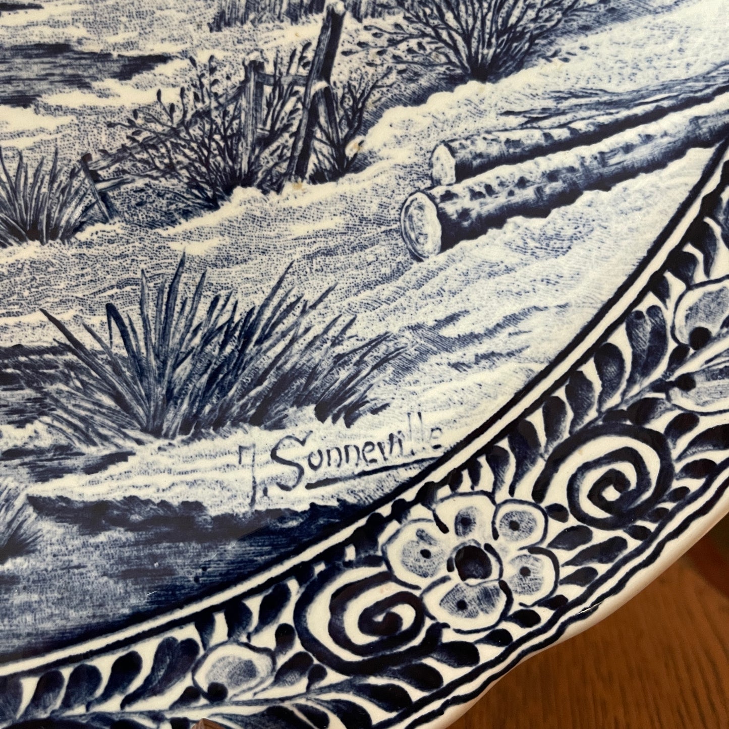 Decorative ceramic plate with desert landscape design and floral patterns