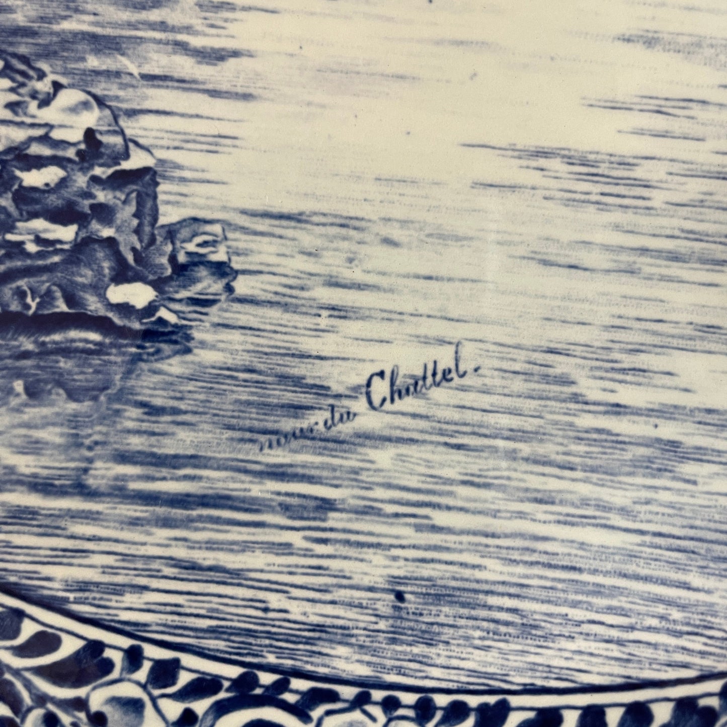 Decorative plate with blue floral patterns and 'Made in Chantel' inscription on a textured beige background