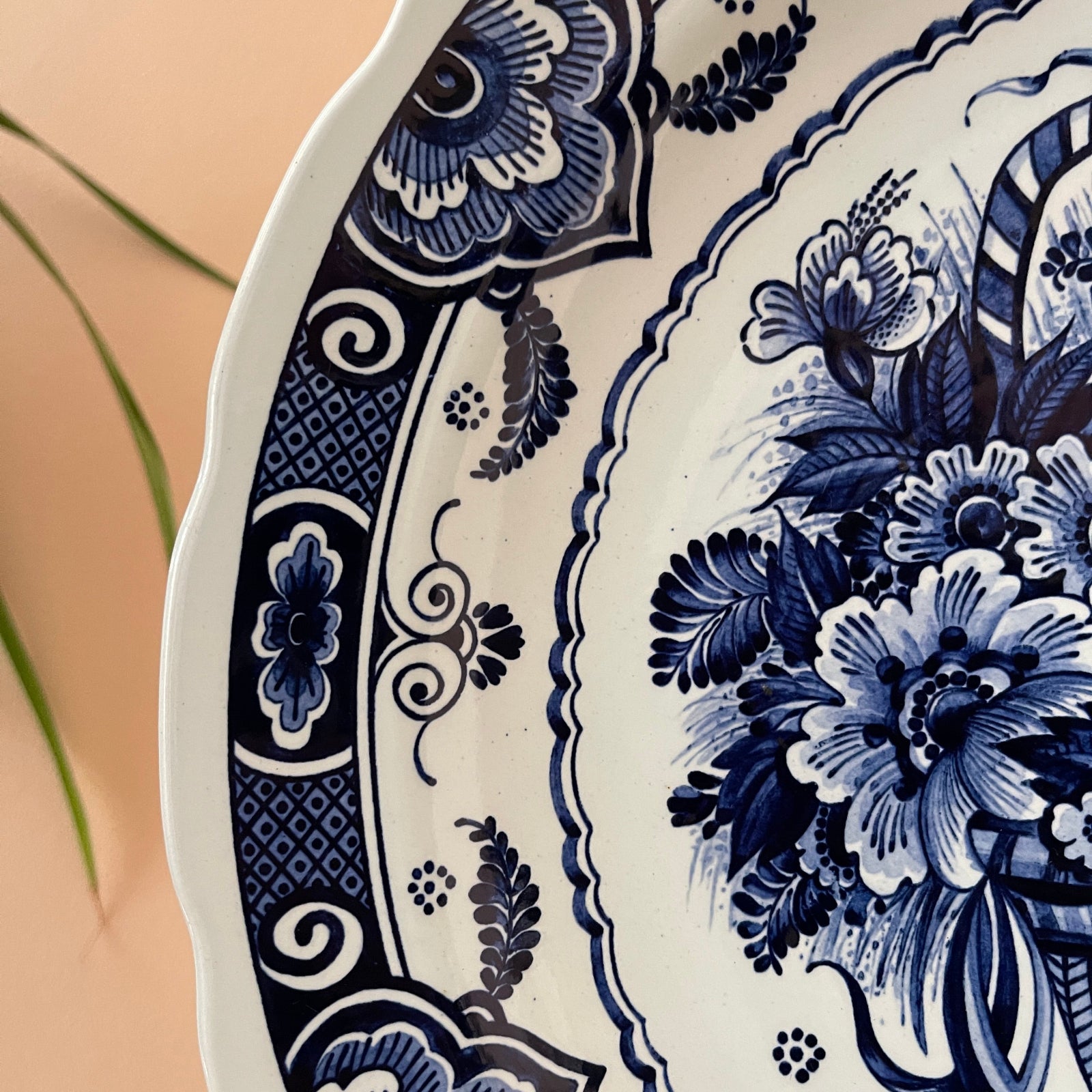 Close-up of a decorative plate with blue floral patterns on a beige background
