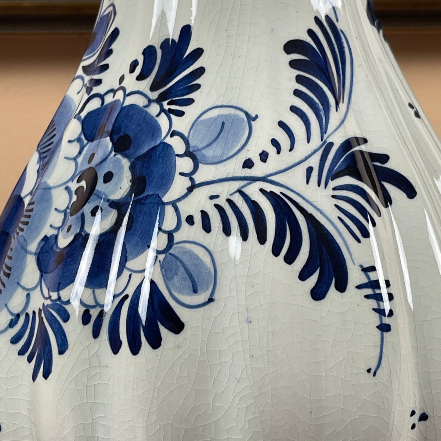 Close-up of a ceramic vase with blue floral patterns on a beige background
