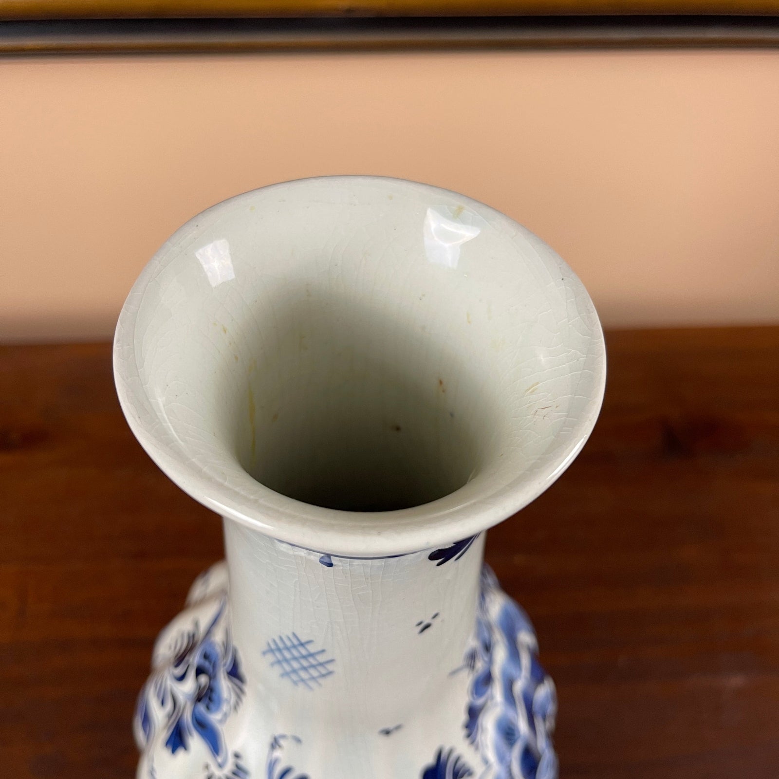 Close-up of a ceramic vase with blue patterns on a wooden surface