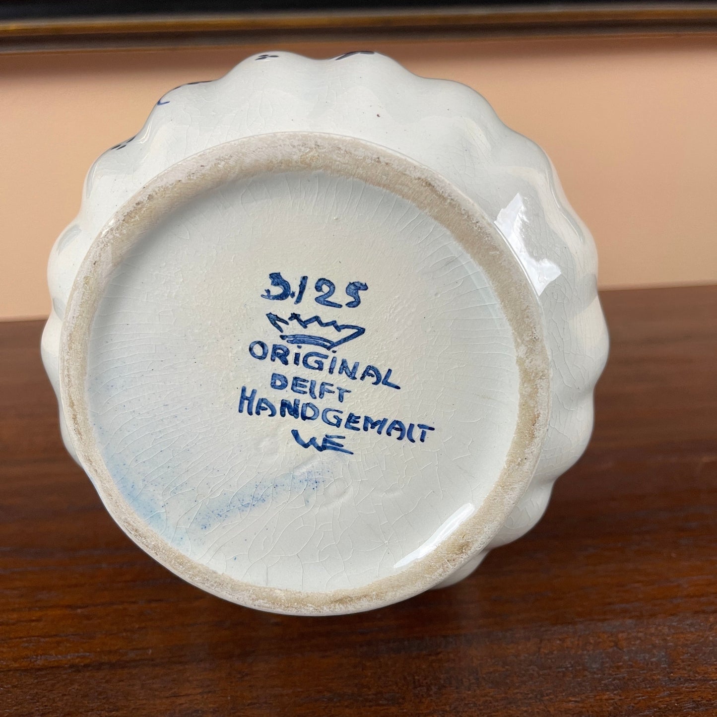 Ceramic vase with blue text on a wooden surface