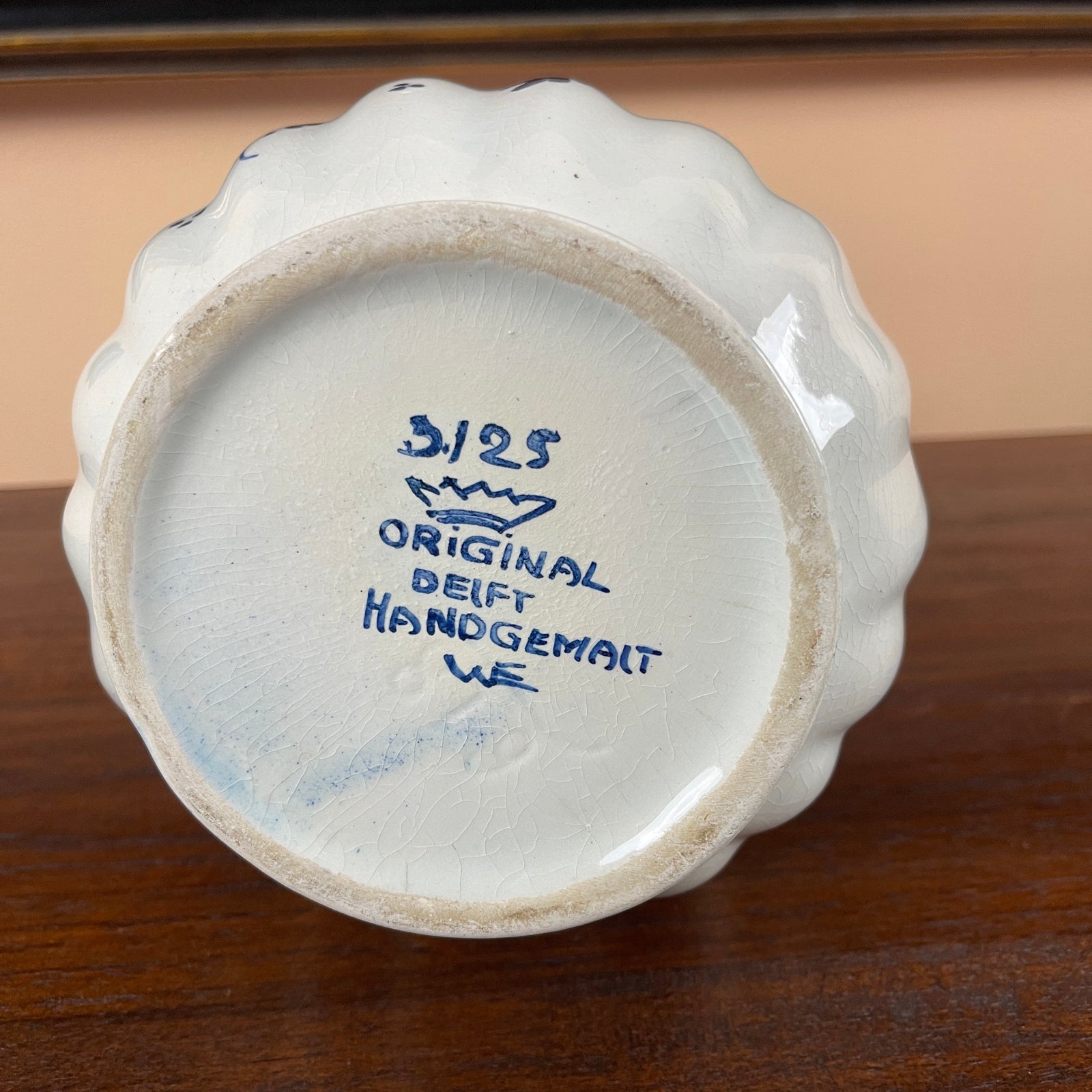 Ceramic vase with blue text on a wooden surface