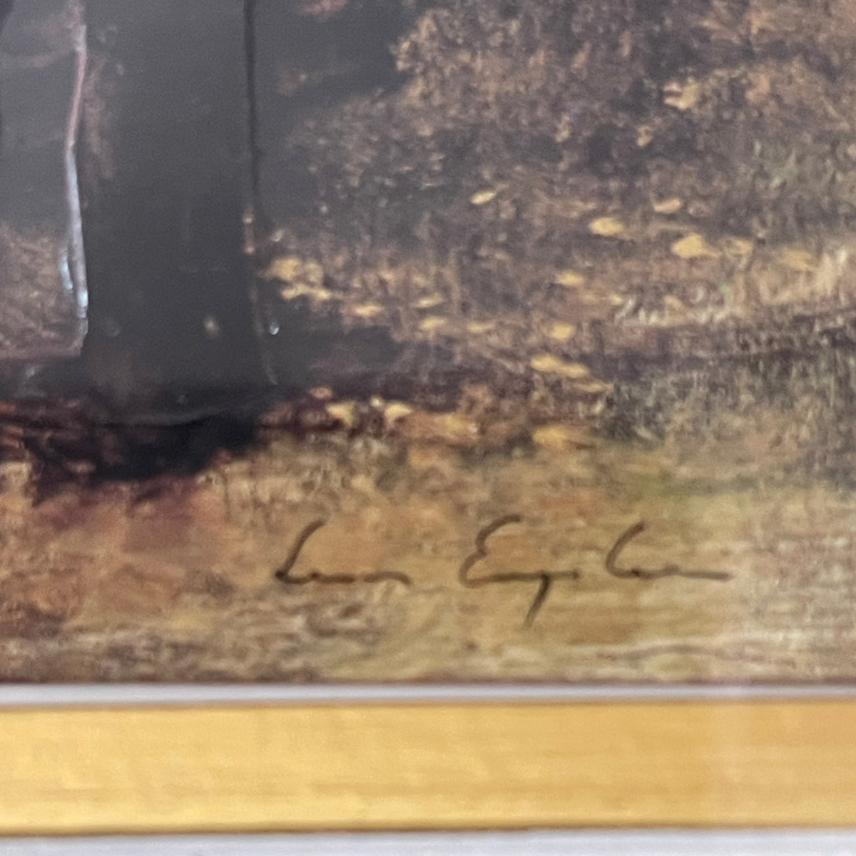 Signature on a textured surface with a gold border