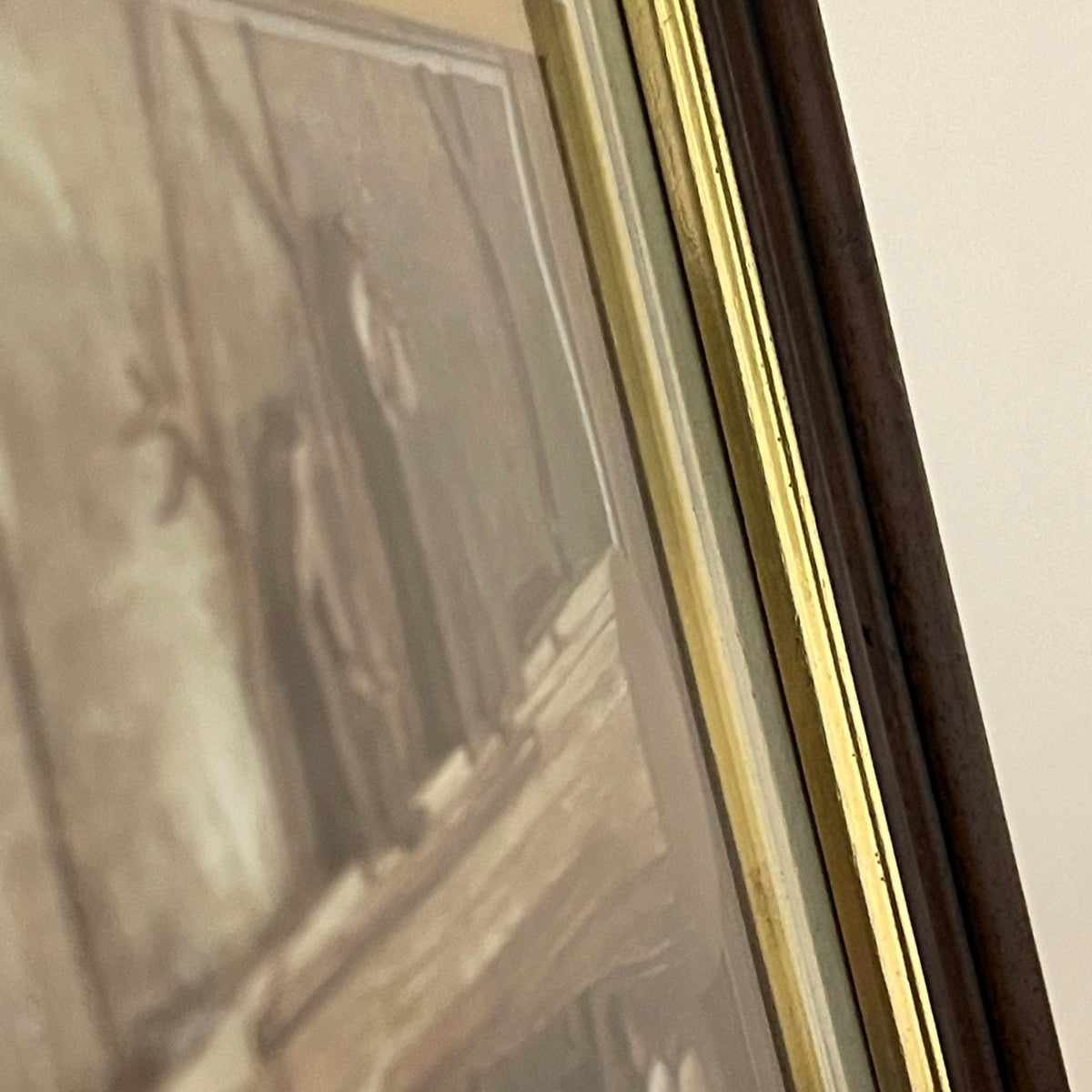 Framed artwork with a gold border on a wall