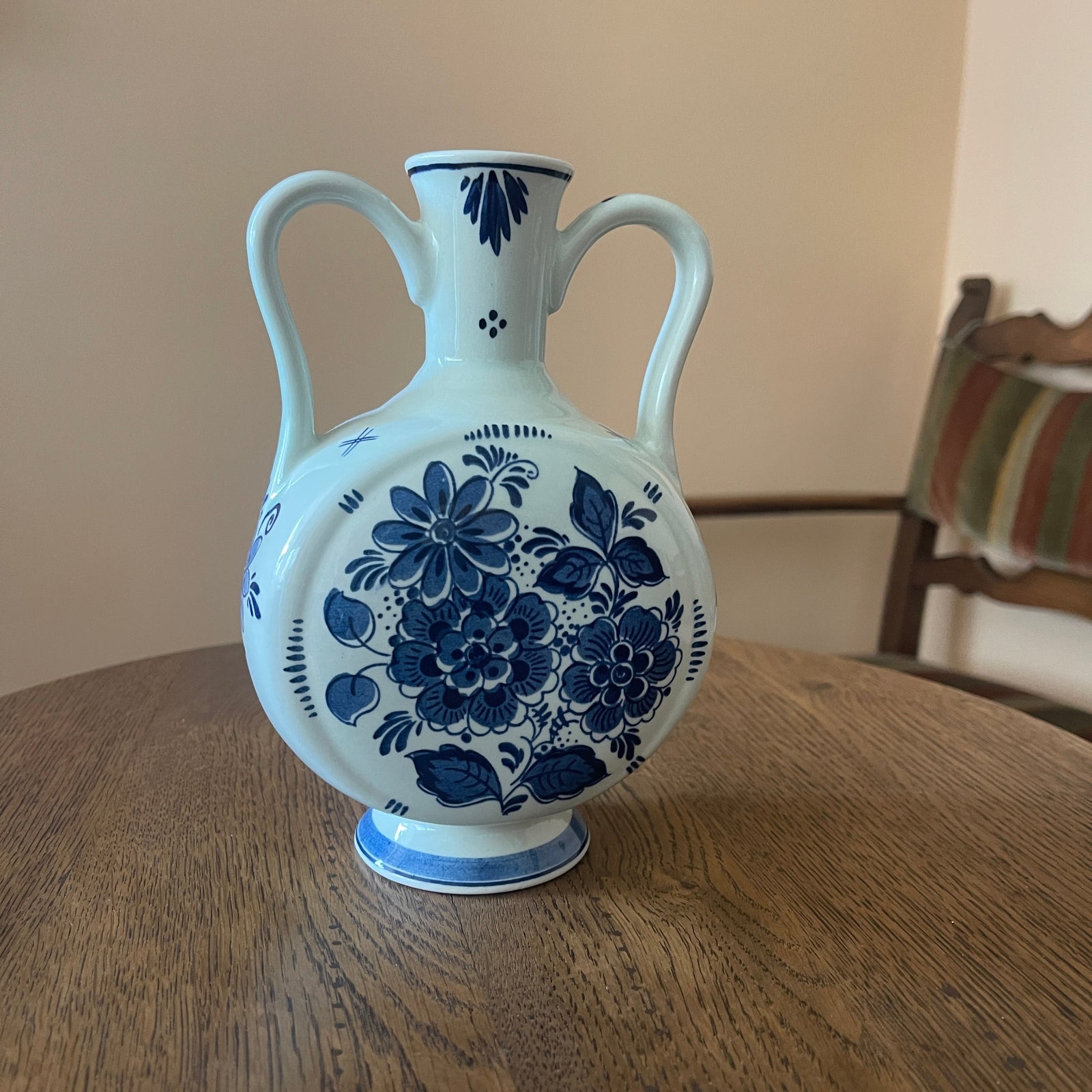 White ceramic vase with blue floral patterns on a wooden table