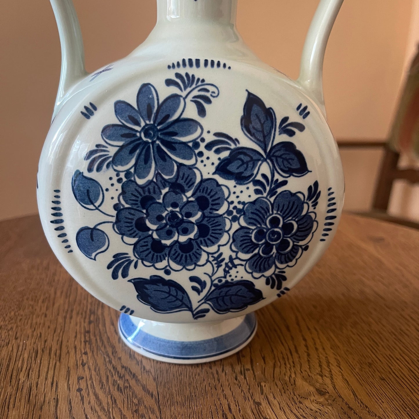 White vase with blue floral patterns on a wooden surface