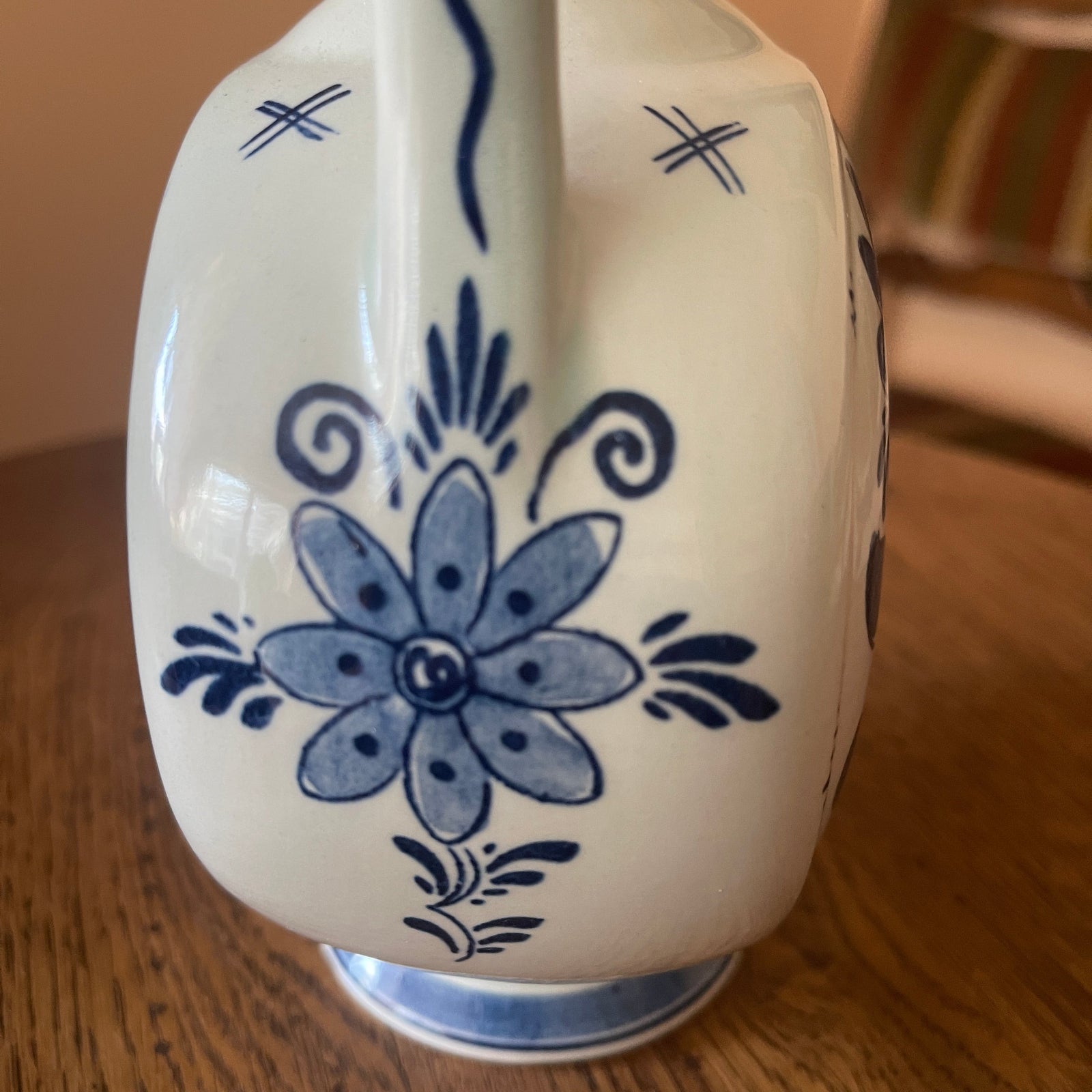 Ceramic piggy bank with blue floral design on a wooden surface