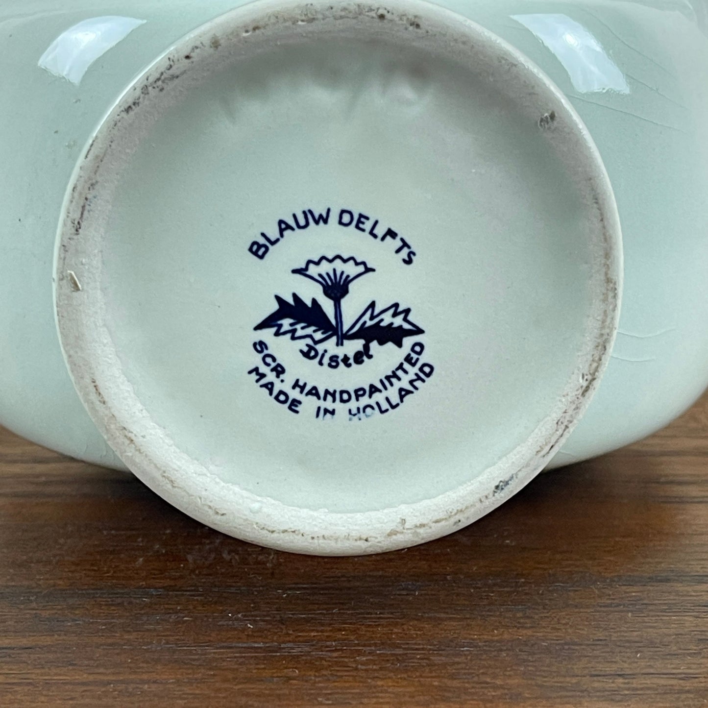 Ceramic product with 'Blauw Delfts' branding on a wooden surface