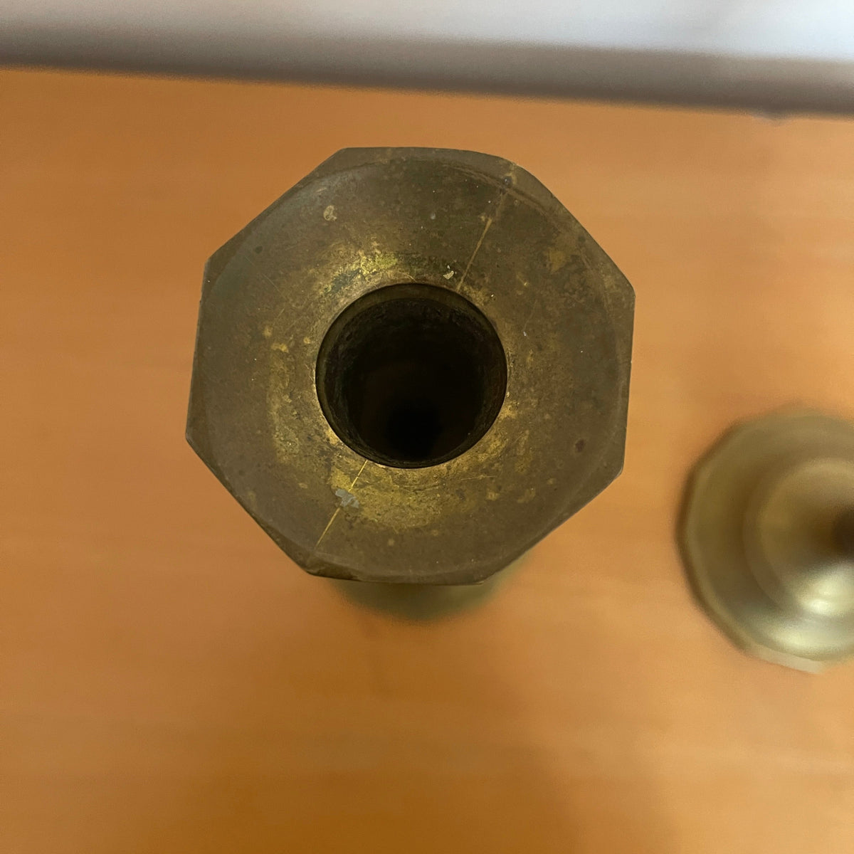 Bronze hexagonal object on a brown surface