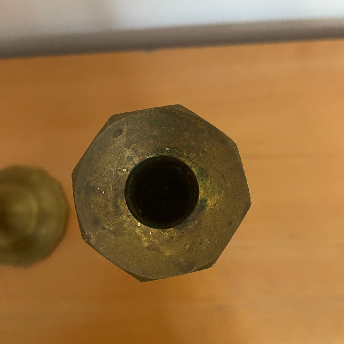Close-up of a metallic hexagonal object on a beige surface