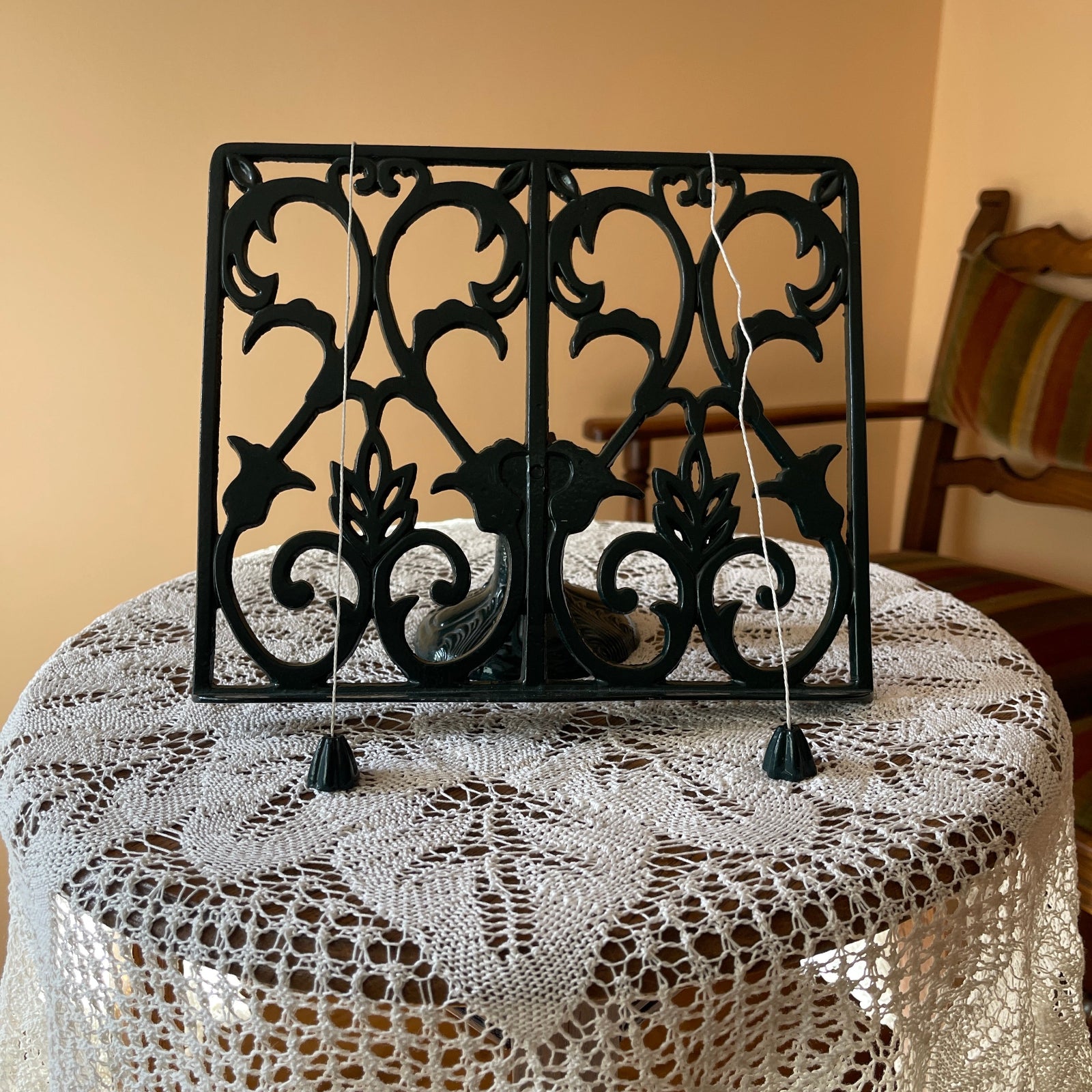 Decorative black metal screen on a table with a lace tablecloth