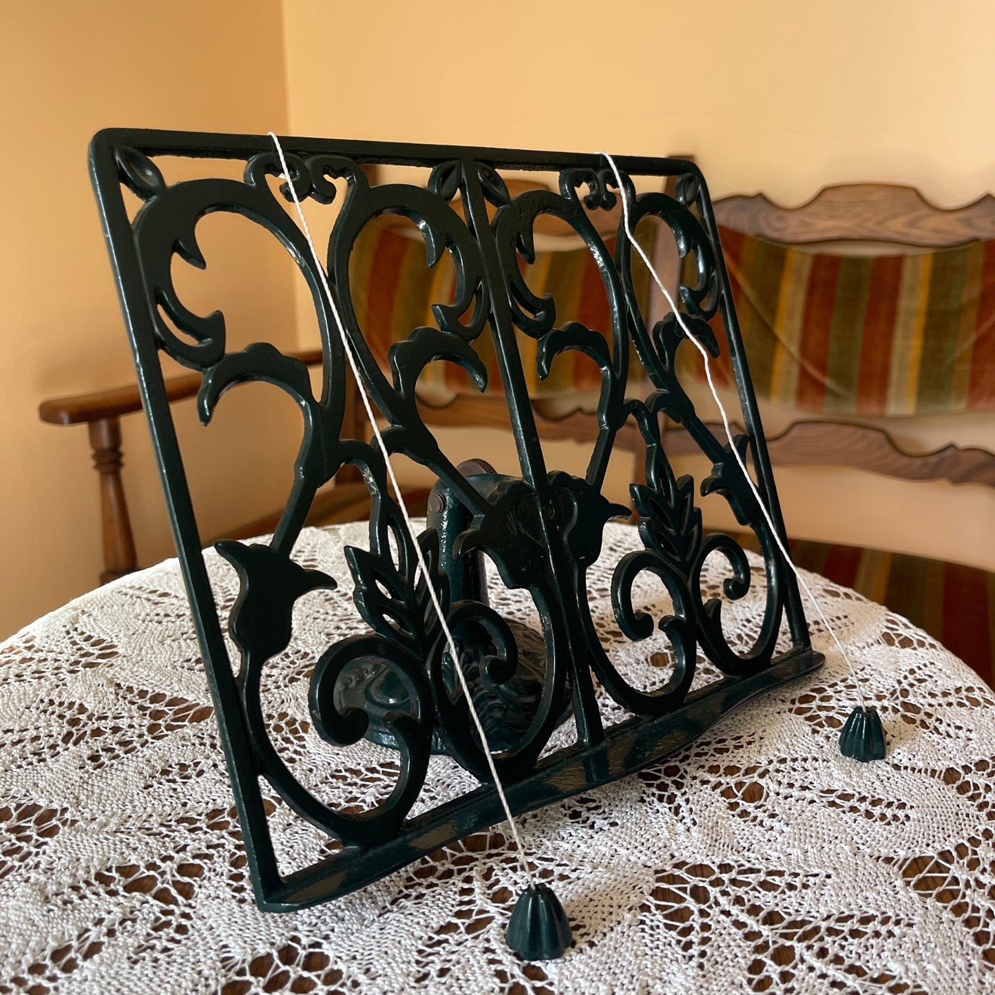 Decorative black metal book holder on a lace tablecloth with a blurred background