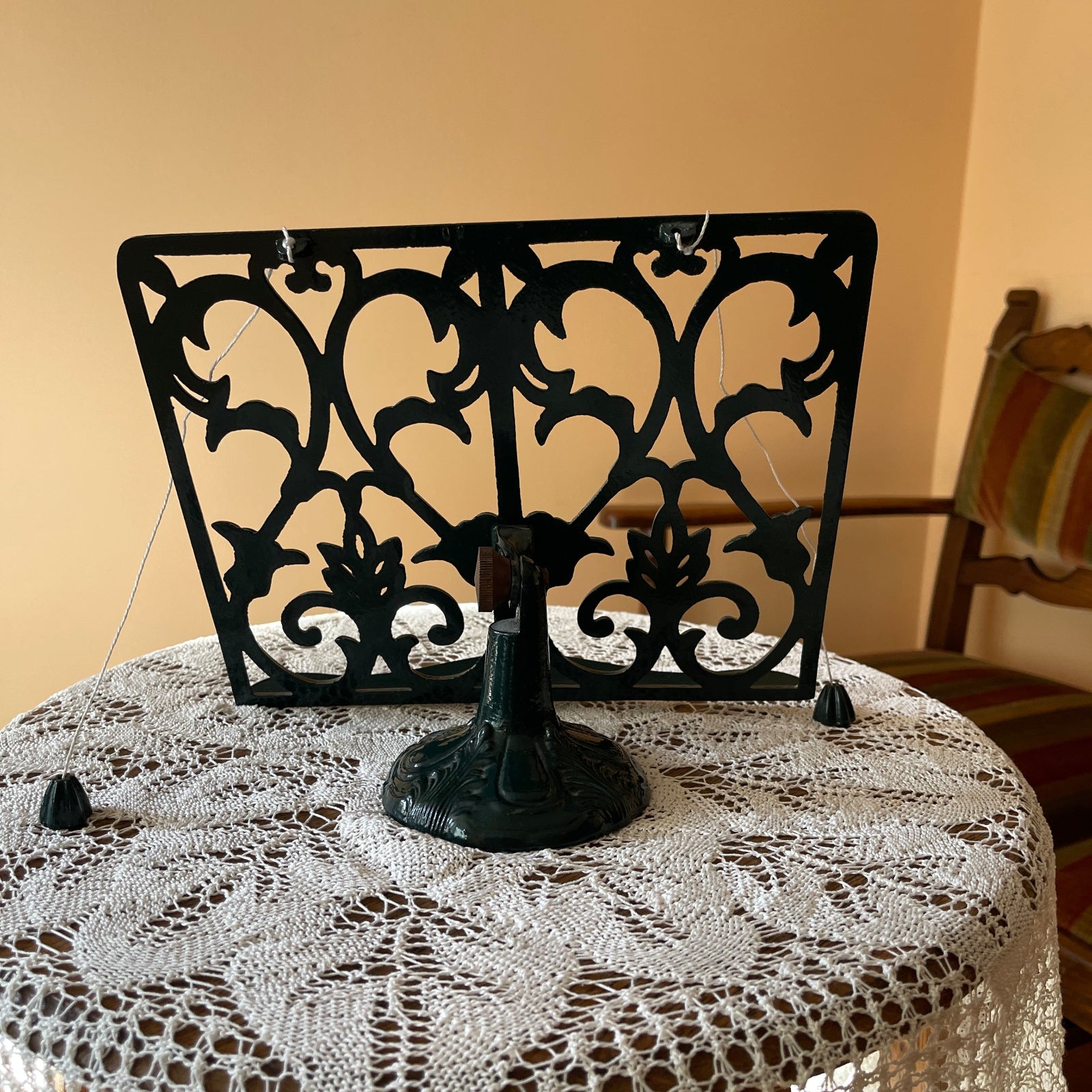 Decorative green metal screen on a table with a lace tablecloth