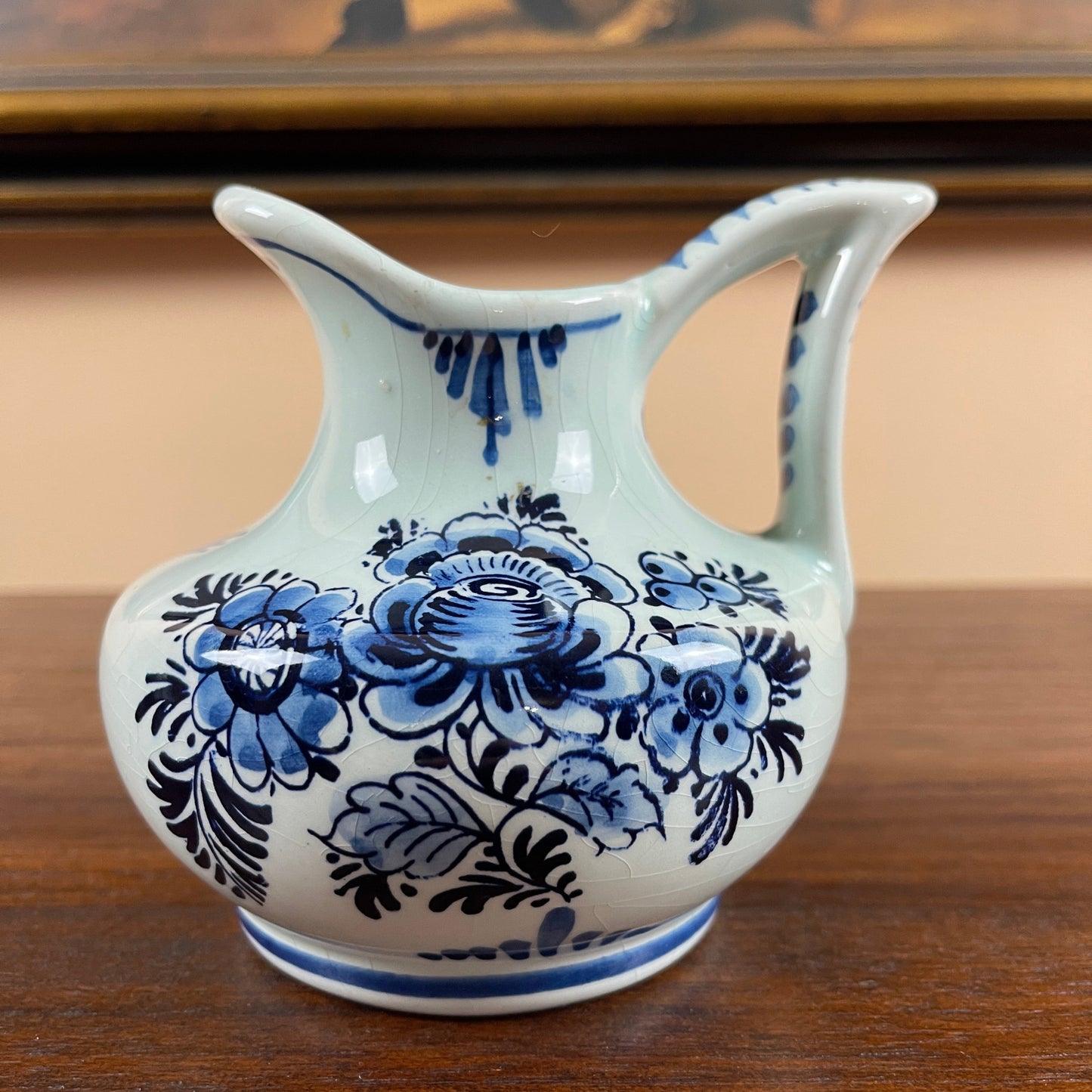Ceramic pitcher with blue floral patterns on a wooden surface