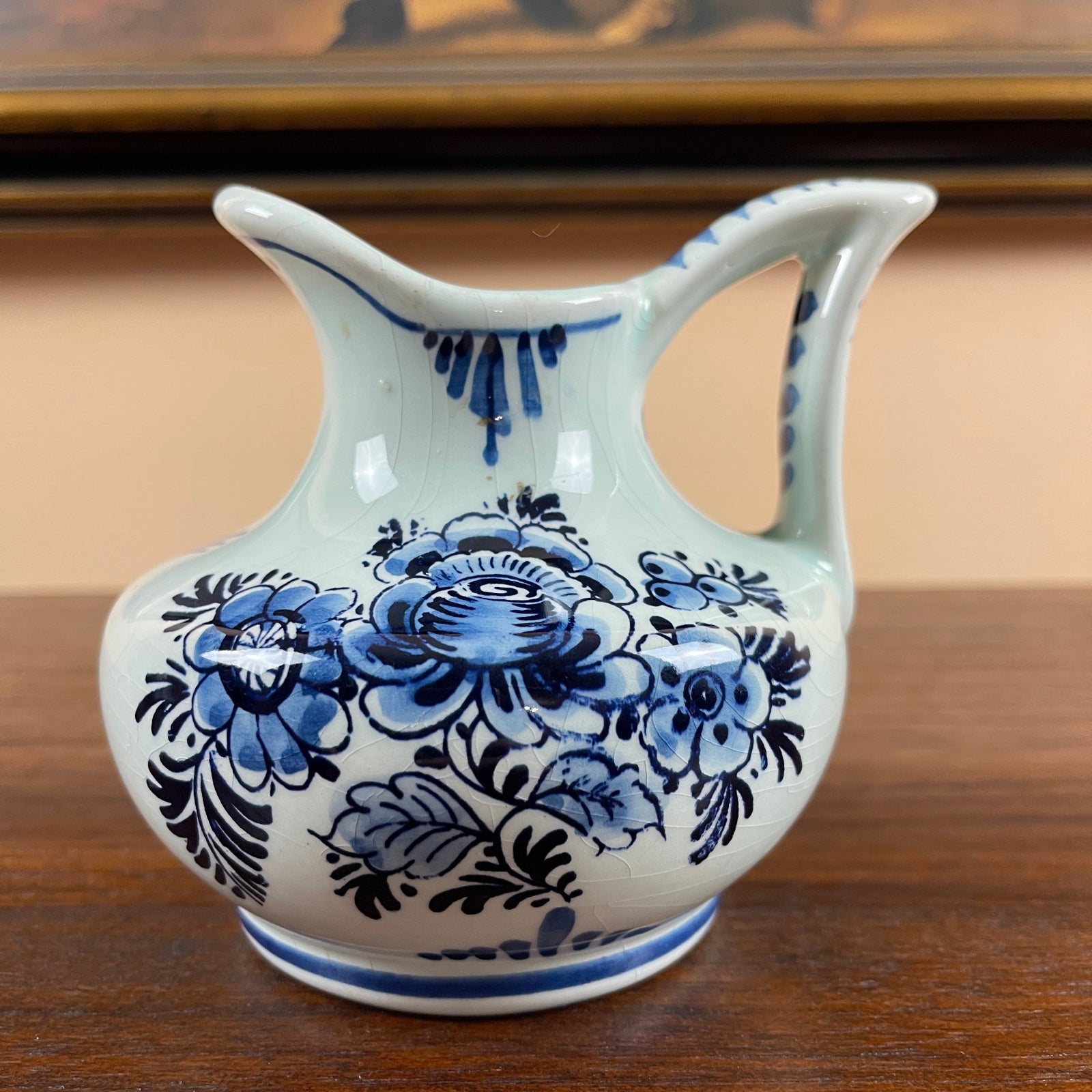 Ceramic pitcher with blue floral patterns on a wooden surface