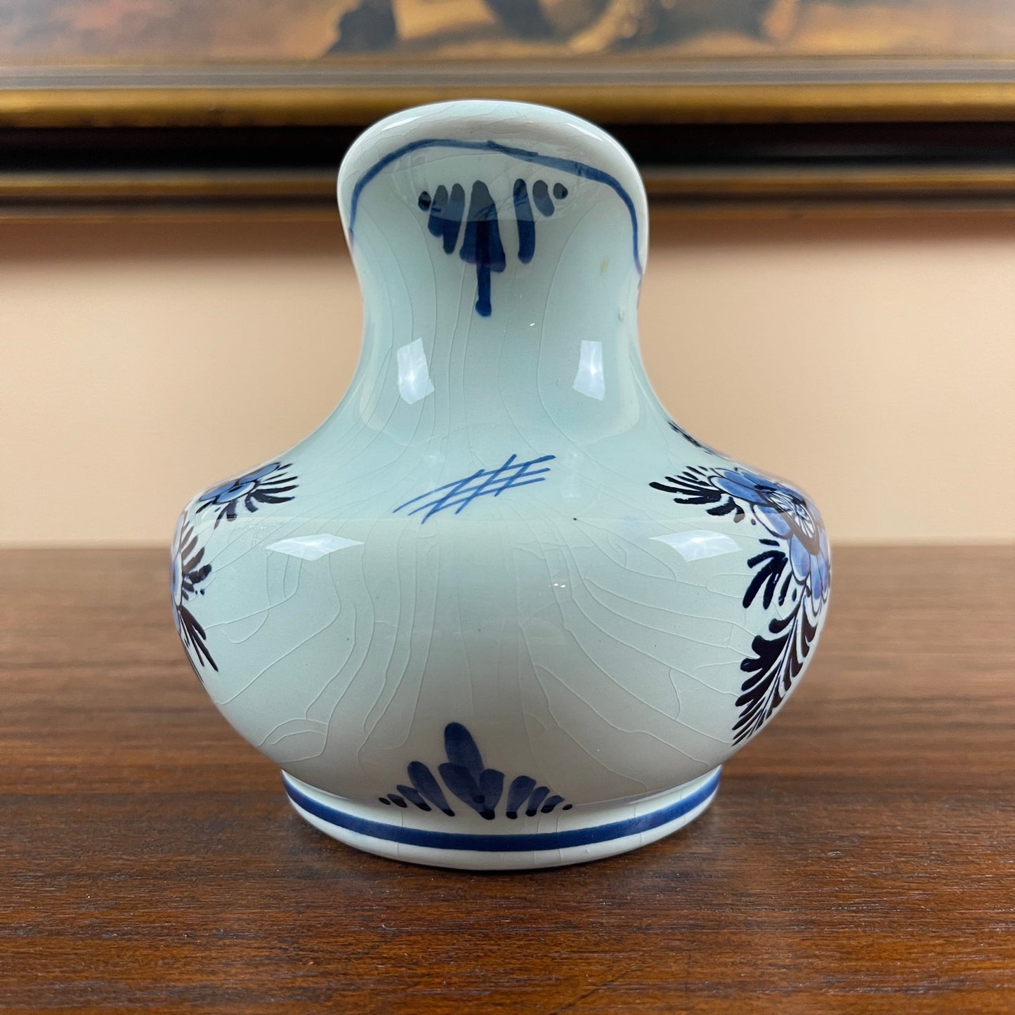 White ceramic vase with blue floral patterns on a wooden surface