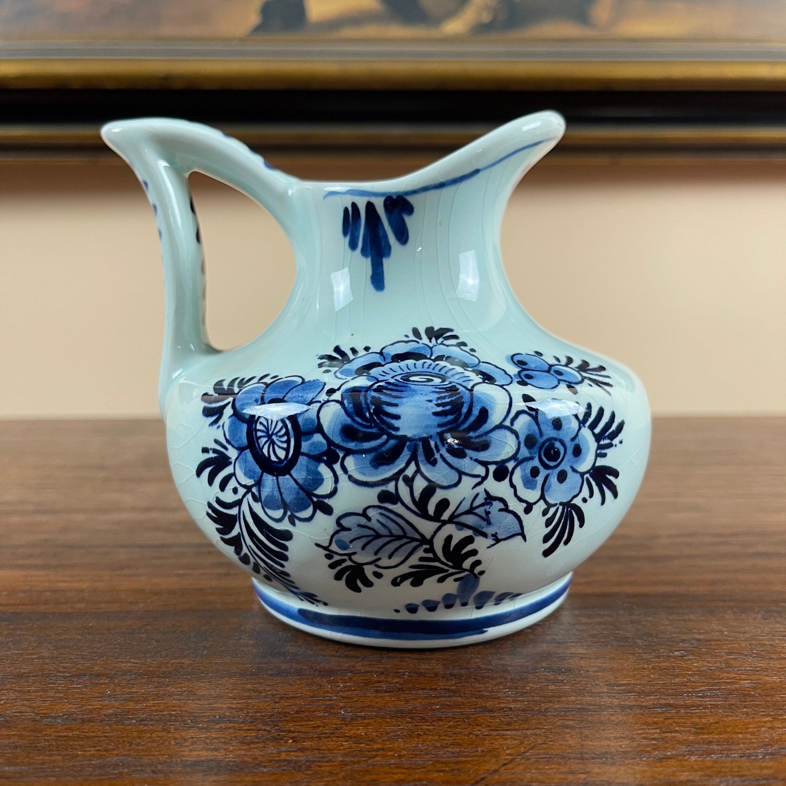 White ceramic pitcher with blue floral patterns on a wooden surface