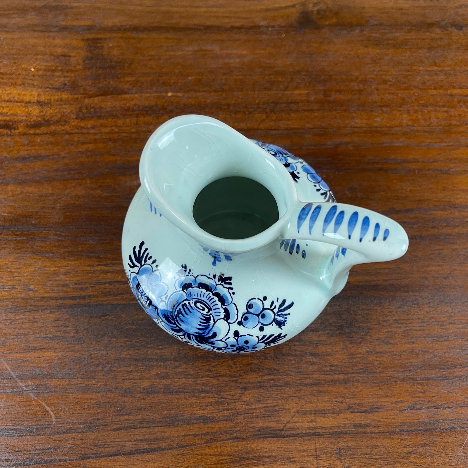 Blue and white ceramic pitcher on a wooden surface