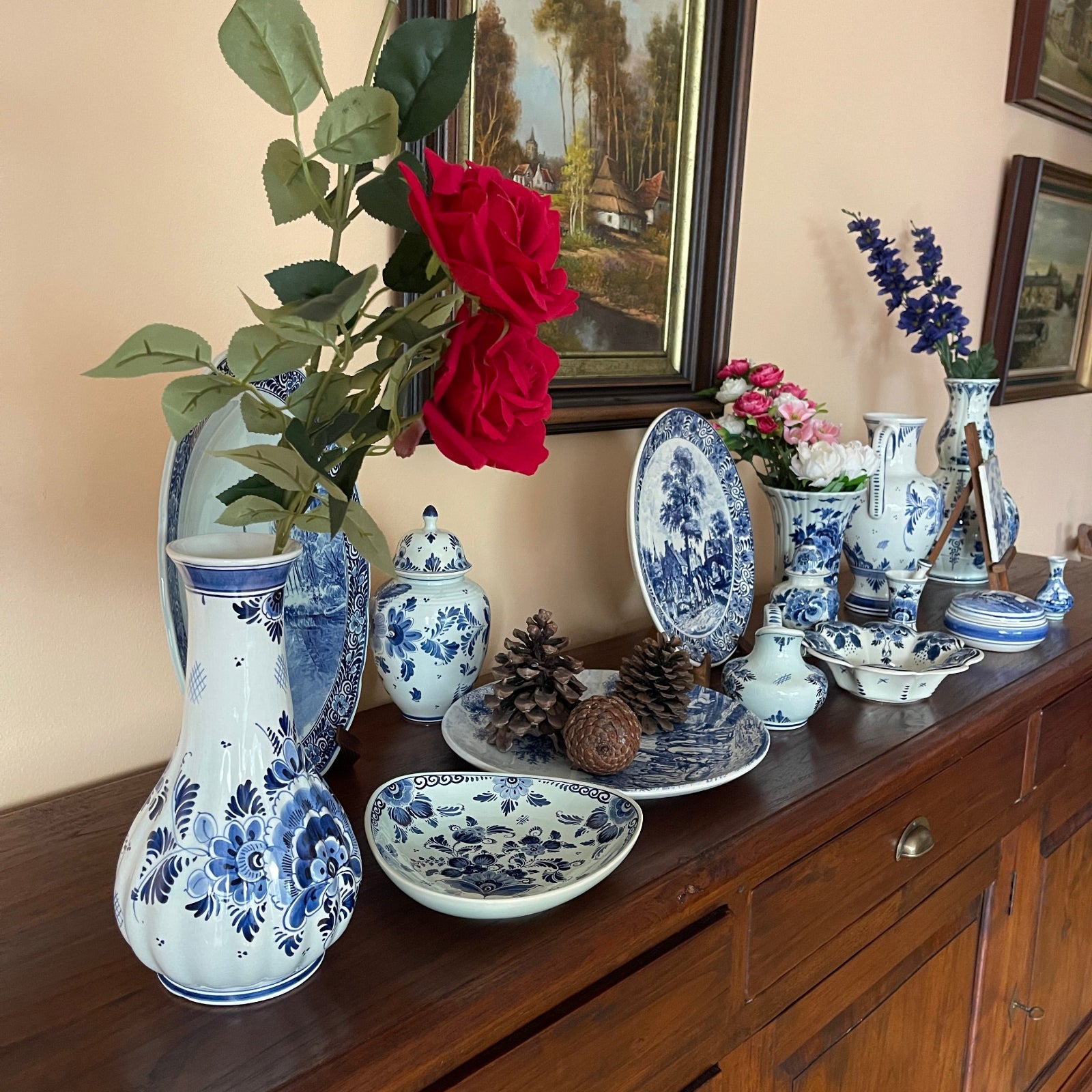 Collection of blue and white ceramic items on a wooden surface with flowers and decorative elements.