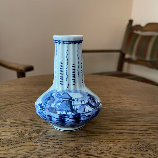 Blue and white ceramic vase on a wooden table with a blurred background
