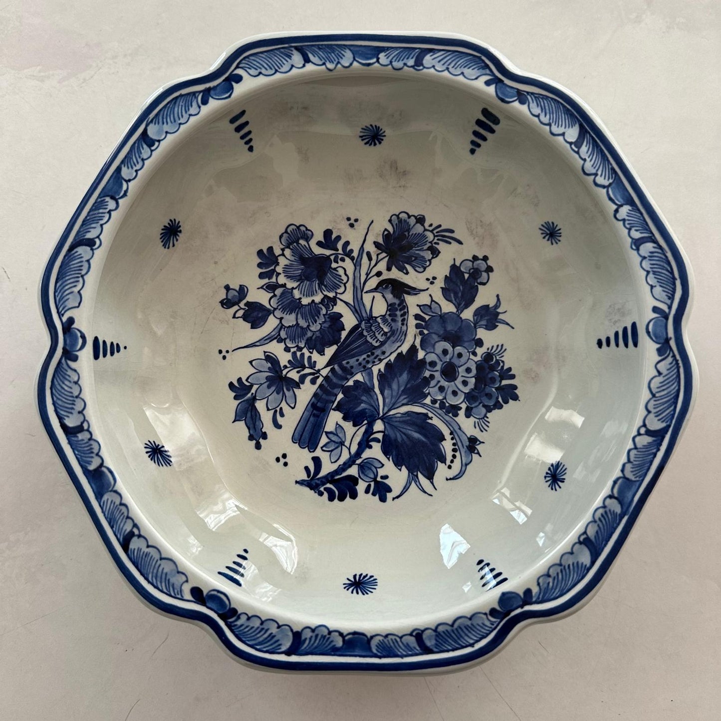 Ceramic plate with blue floral and bird design on a white background