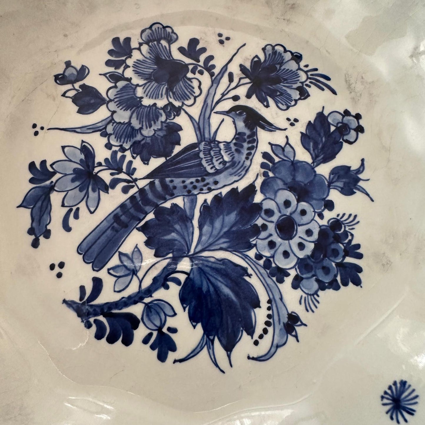 Decorative plate with blue floral and bird design on a white background