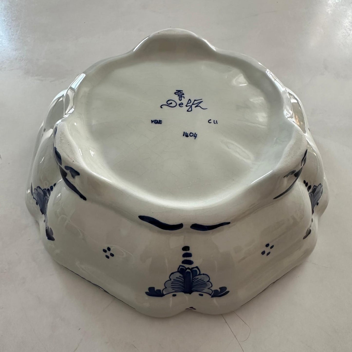White ceramic dish with blue floral patterns and 'Delft' branding on a white background