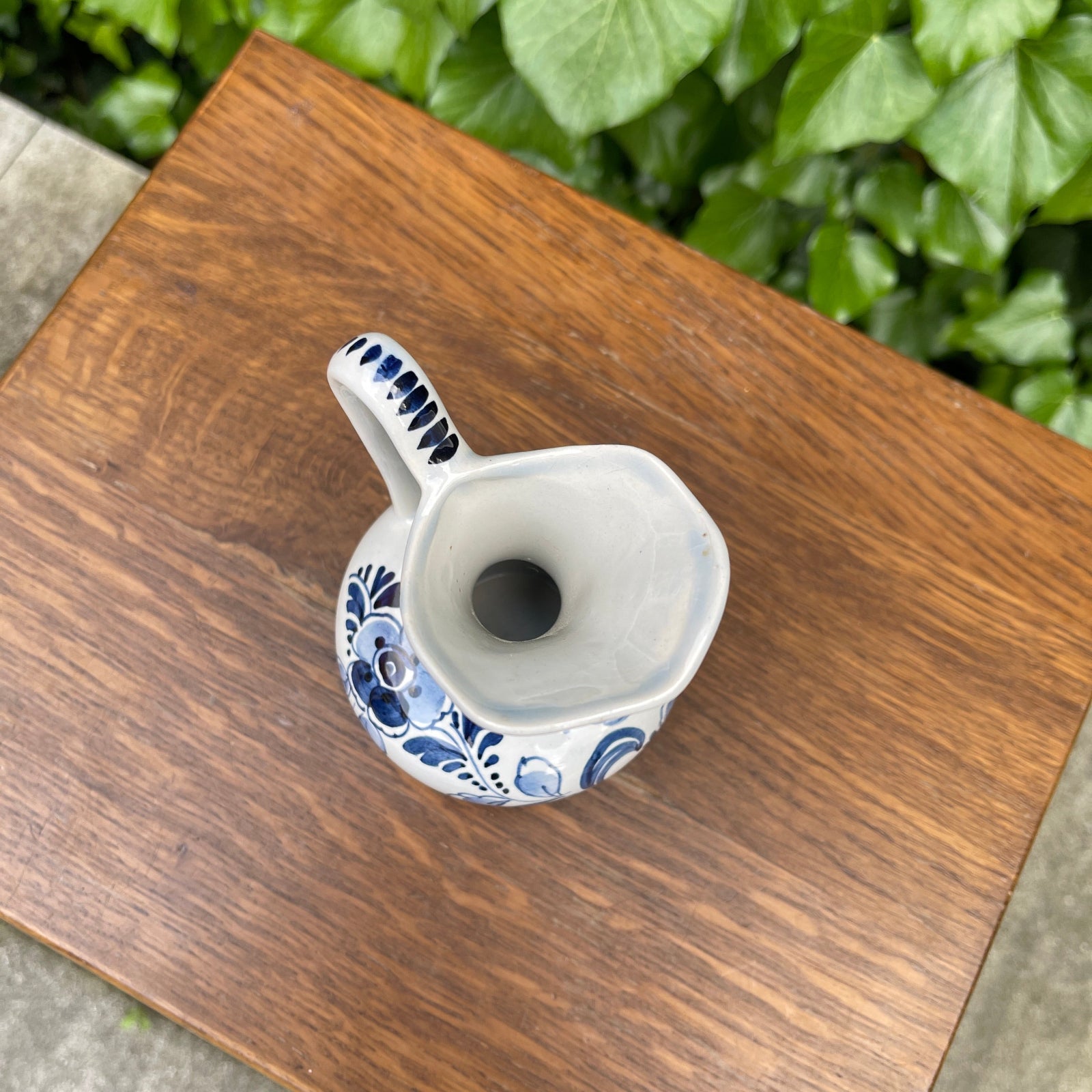 Ceramic pitcher with blue floral patterns on a wooden surface
