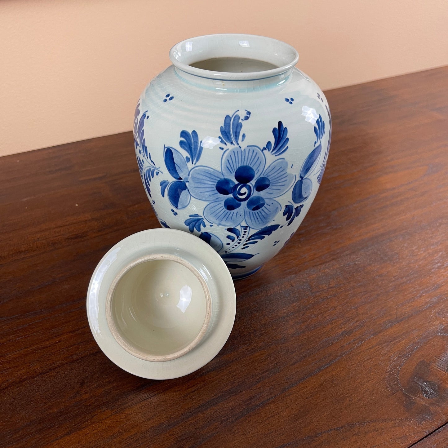 Ceramic jar with blue floral patterns on a wooden surface