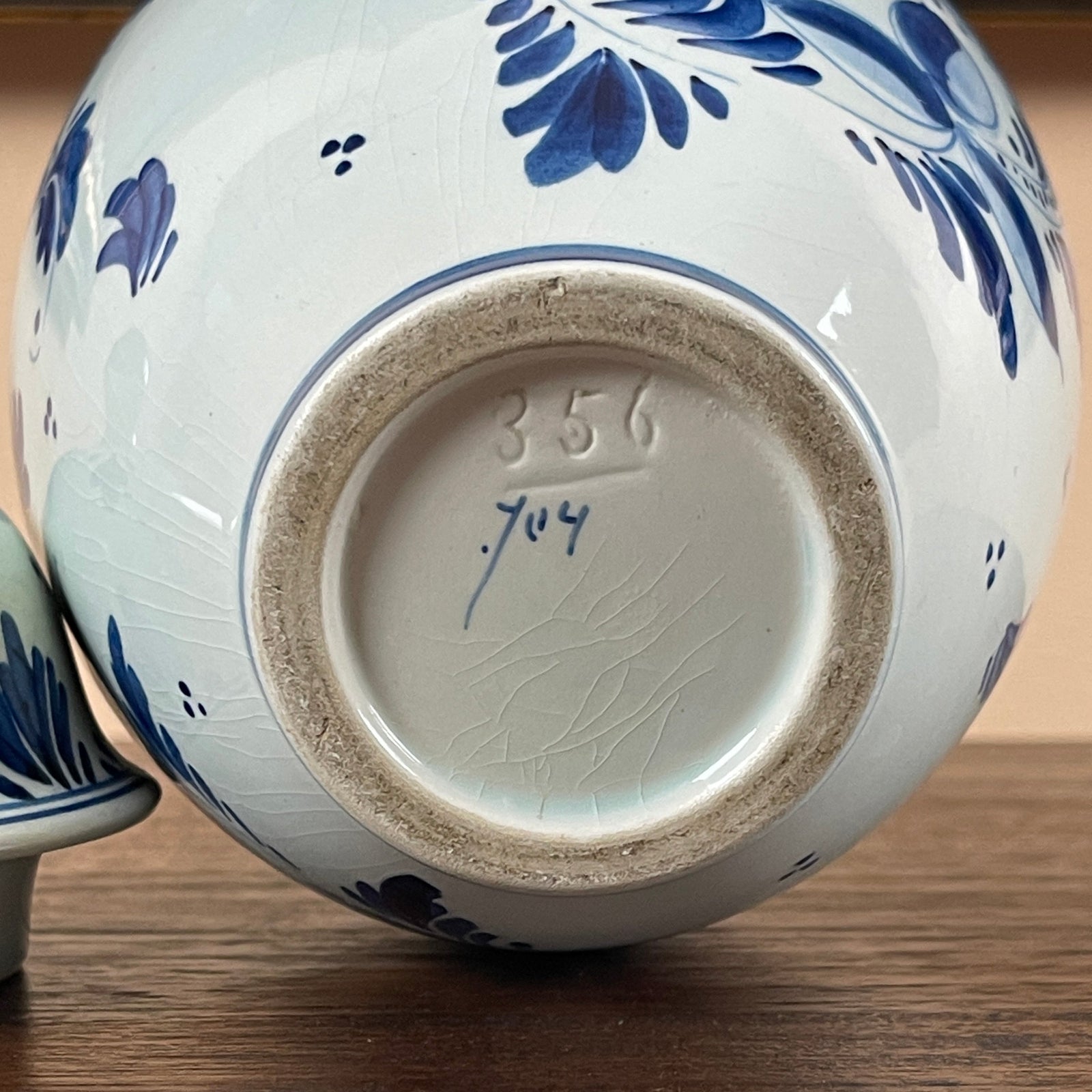 Ceramic jar with blue floral patterns on a wooden surface