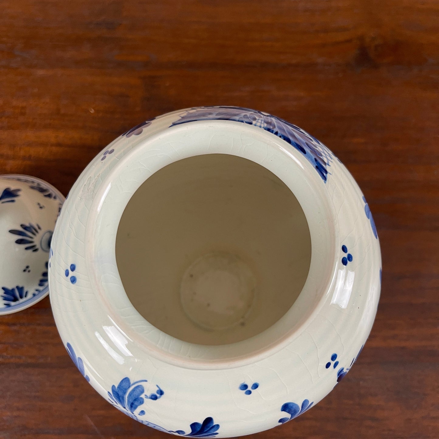 Ceramic jar with blue floral patterns on a wooden surface