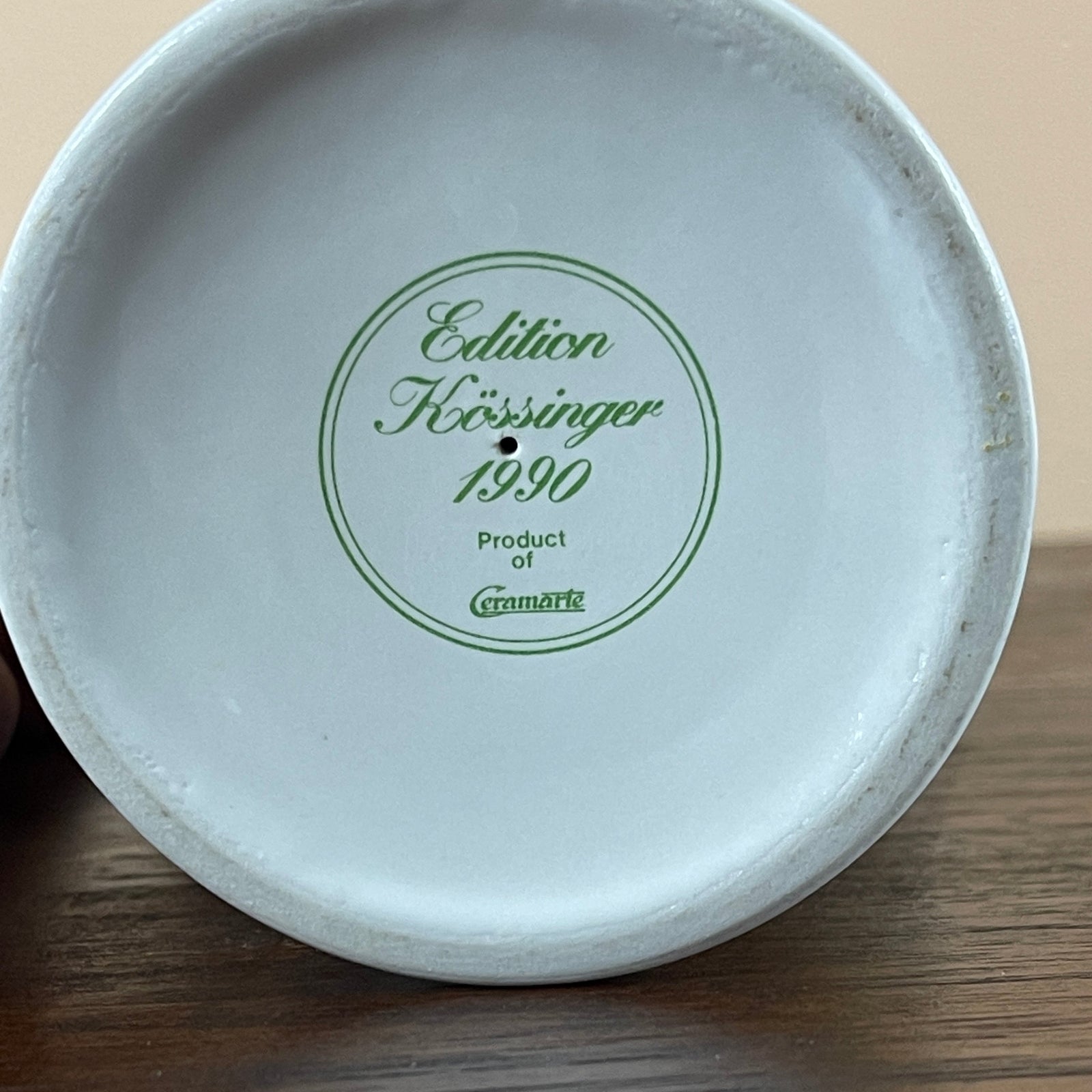 White ceramic plate with green text on a wooden surface