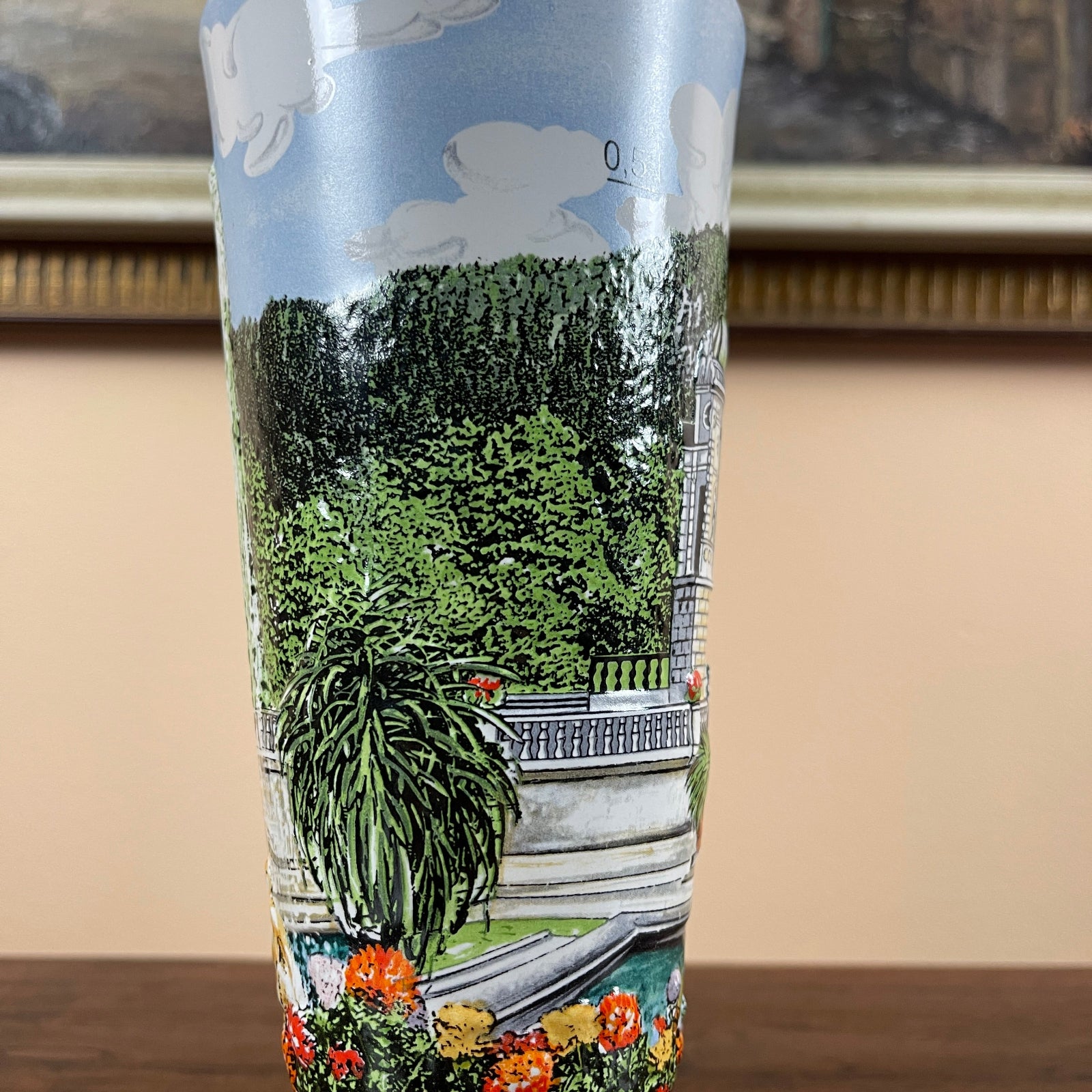 Tumbler with a scenic design of trees and flowers on a beige background