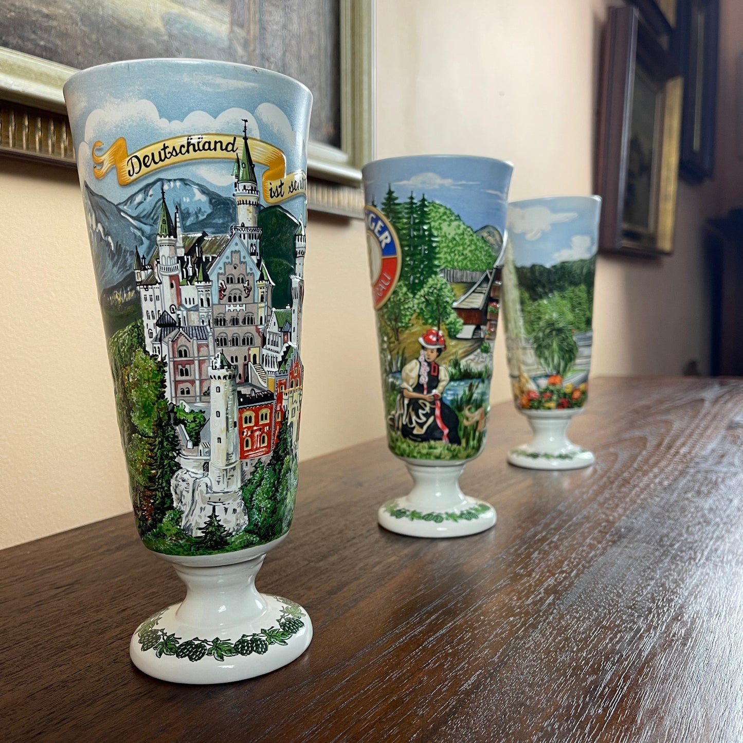 Decorative glasses with scenic designs on a wooden surface