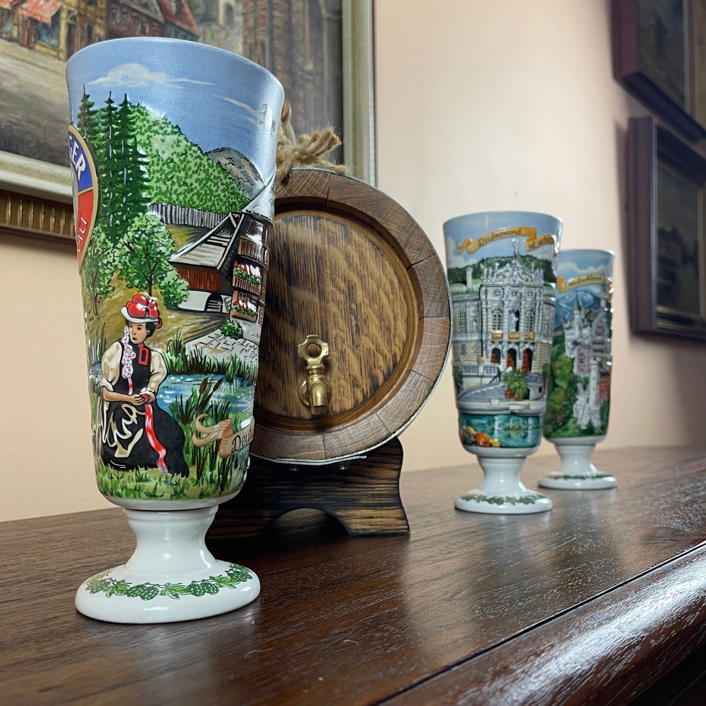 Decorative ceramic cups with scenic designs on a wooden surface