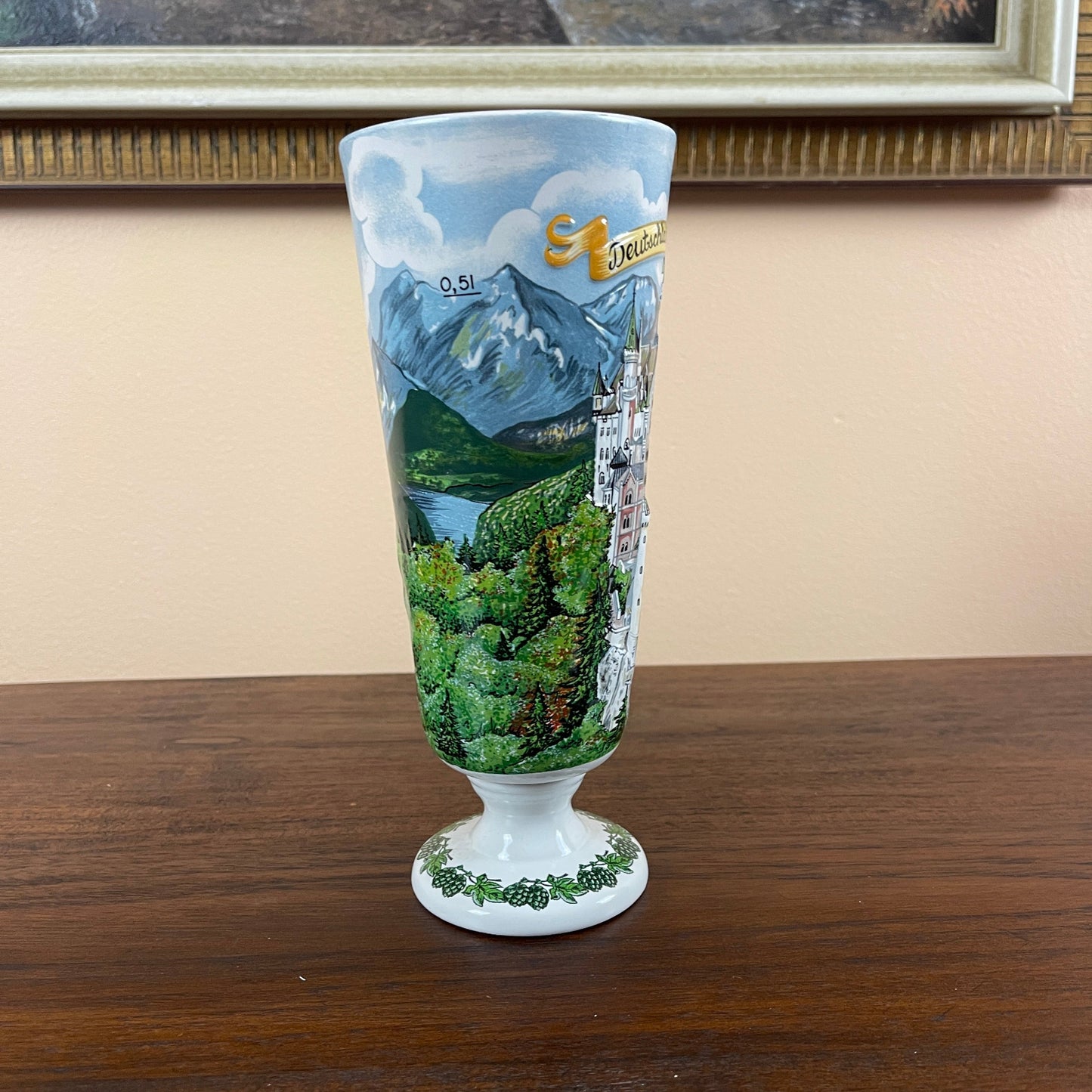 Decorative glass with mountain and landscape design on a wooden surface